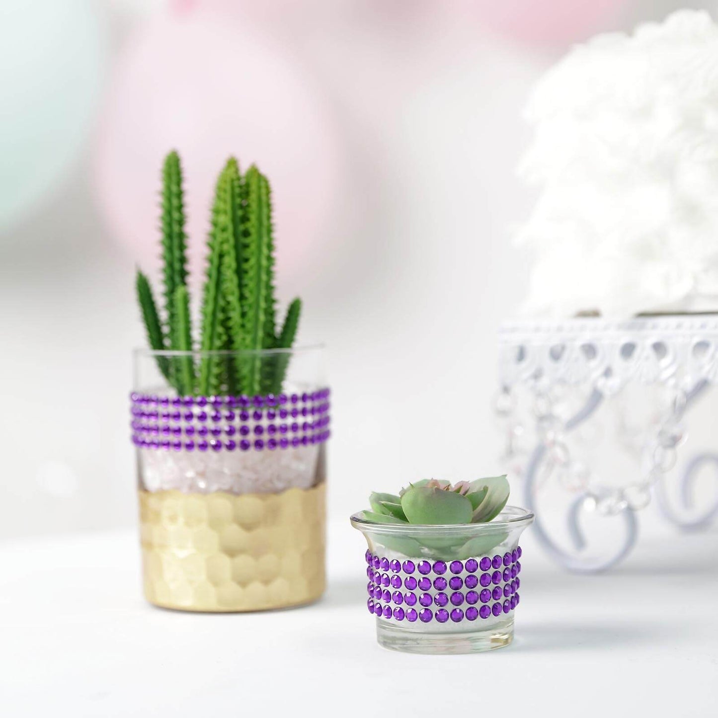 Purple rhinestone tape on decorative glass vases with plants.
