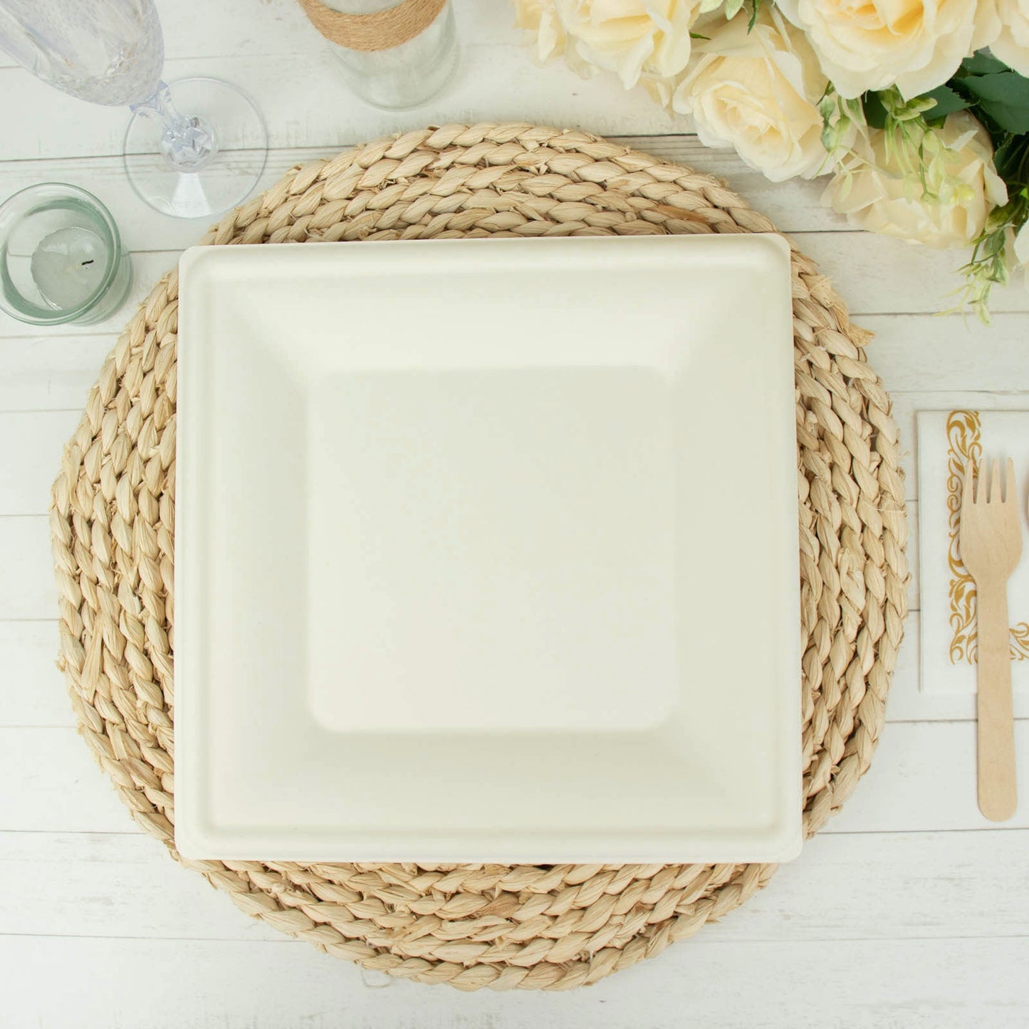White biodegradable bagasse square dinner plate on a natural placemat.
