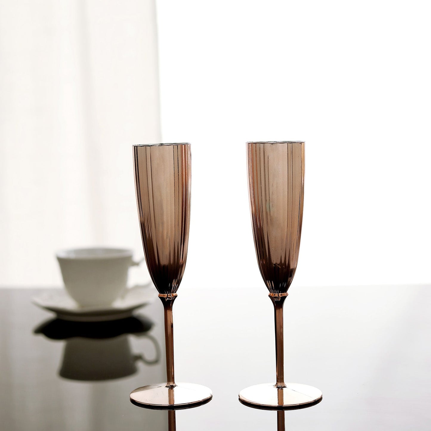Rose gold disposable champagne flutes on a table.