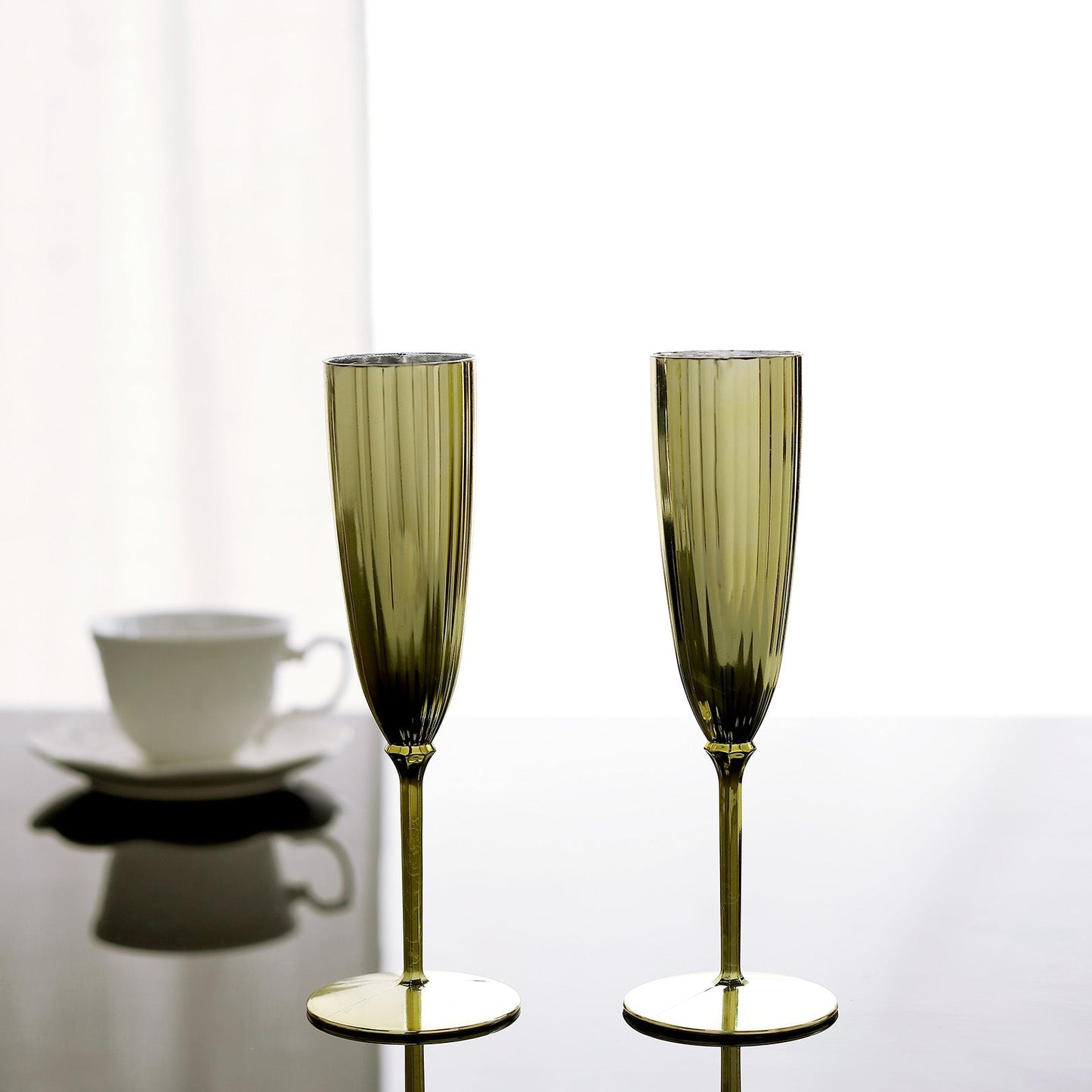 Metallic gold disposable champagne flutes on a table.