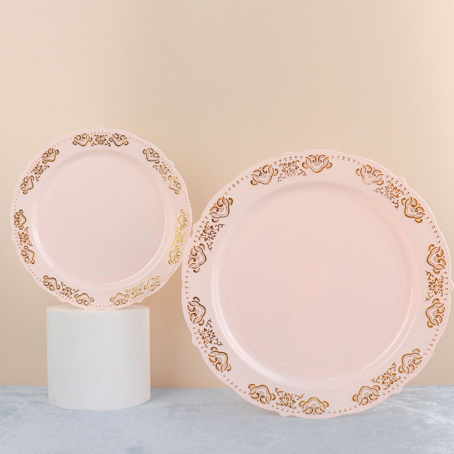 Blush pink round plastic appetizer plates with gold embossed scalloped edges.