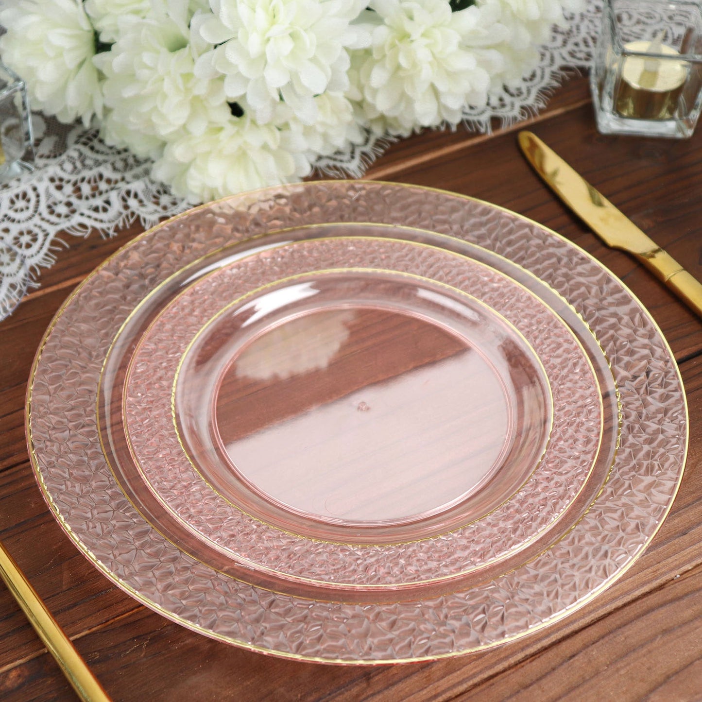 Blush plastic dessert plates with gold rim and hammered design.