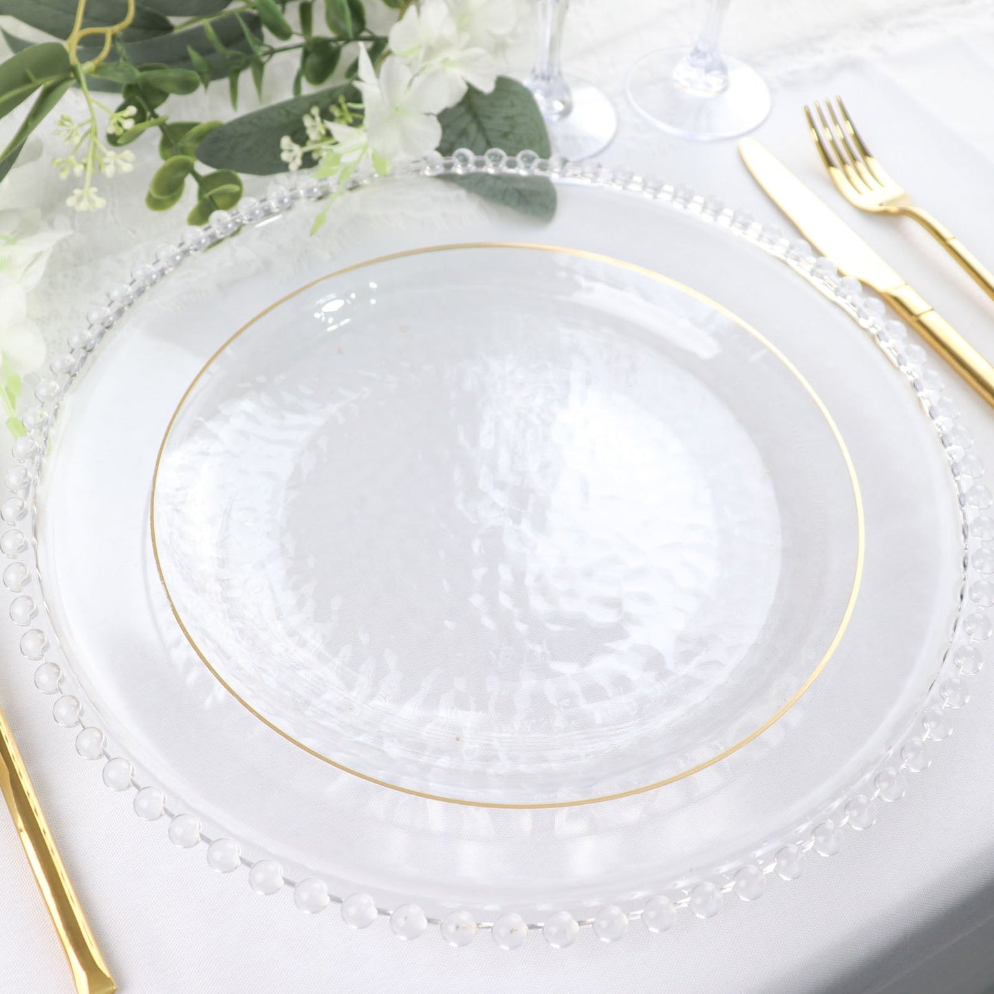 Clear hammered plastic dinner plate with gold rim.