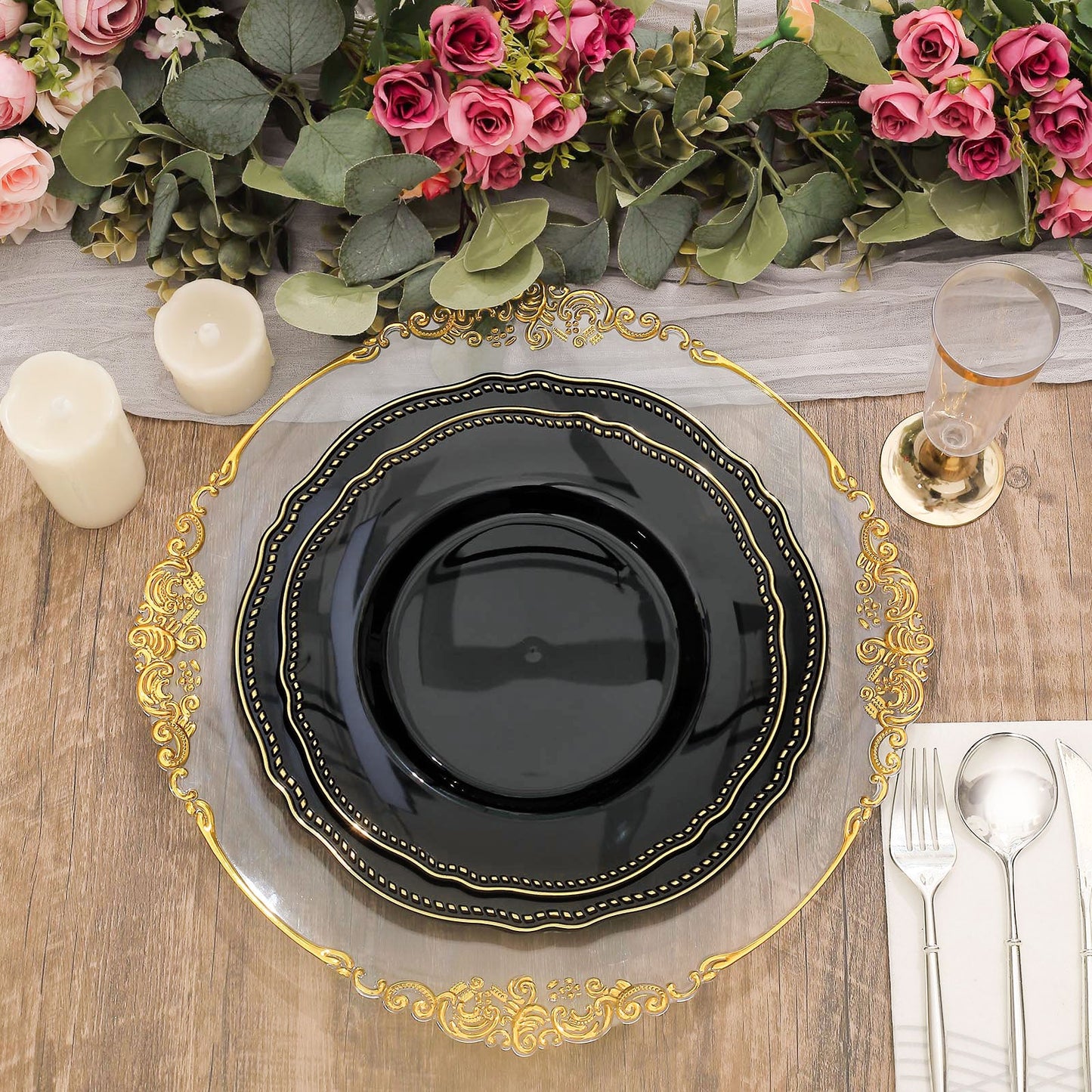 Elegant black plate on a gold-trimmed charger with candles and floral arrangement.