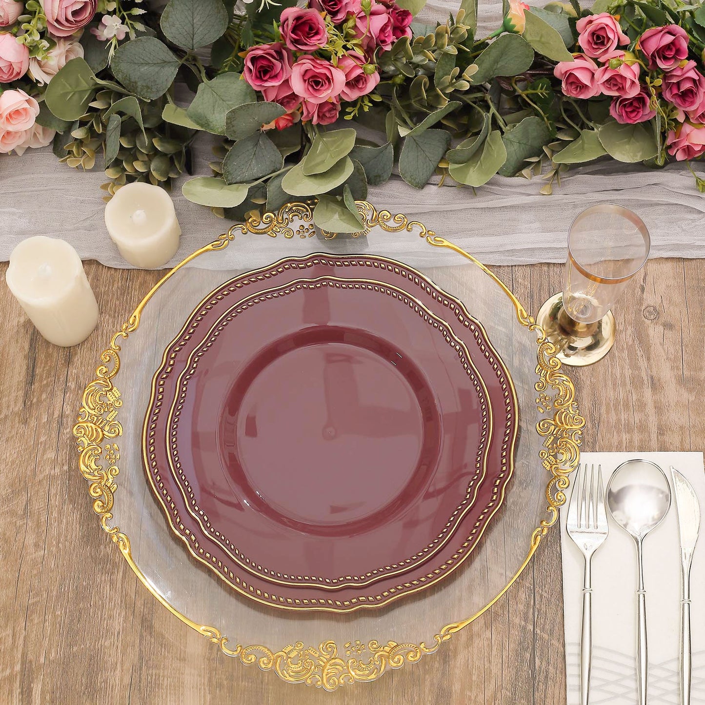 Elegant table setting with burgundy plate, gold accents, and floral decor.