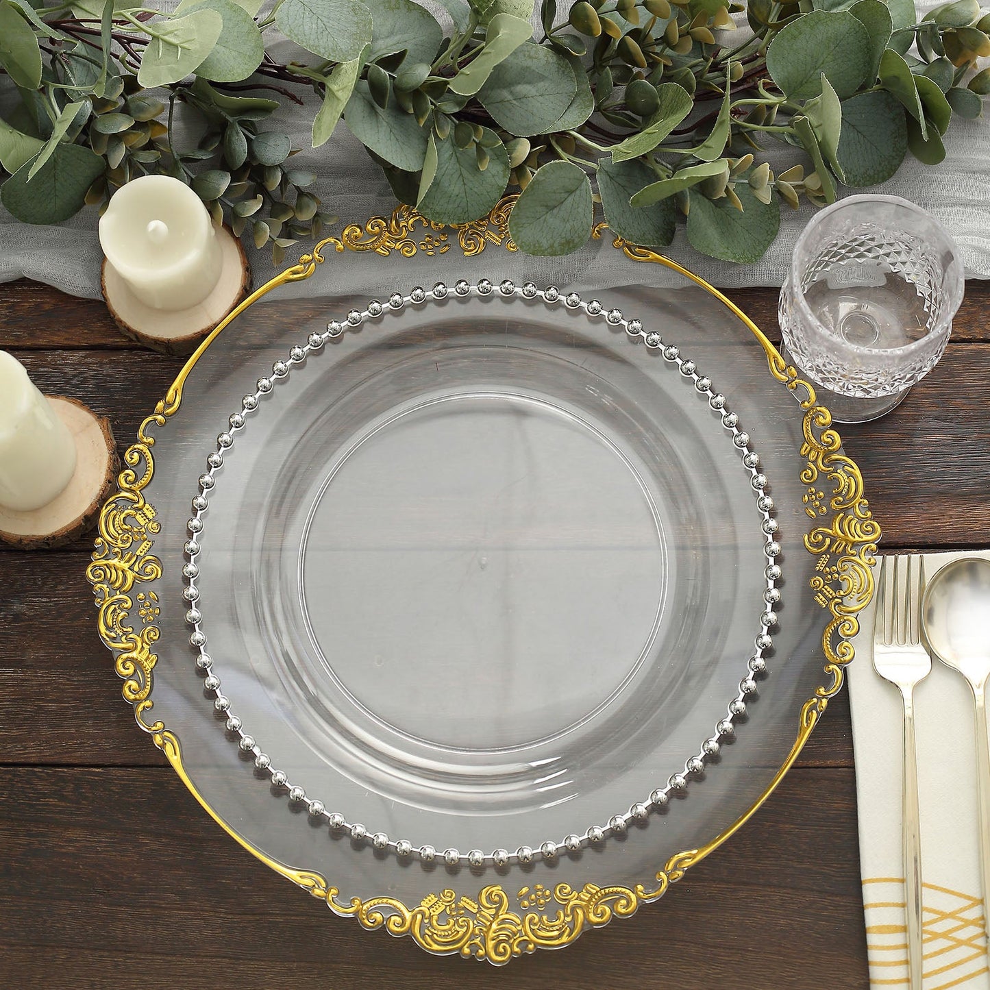 Clear plastic dinner plate with silver beaded rim on a decorative table setting.