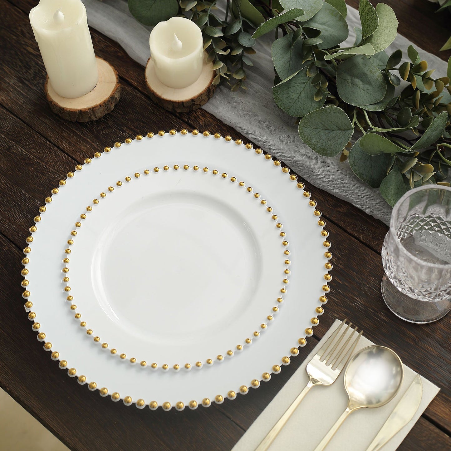 White plastic dessert plates with a gold beaded rim, perfect for parties.
