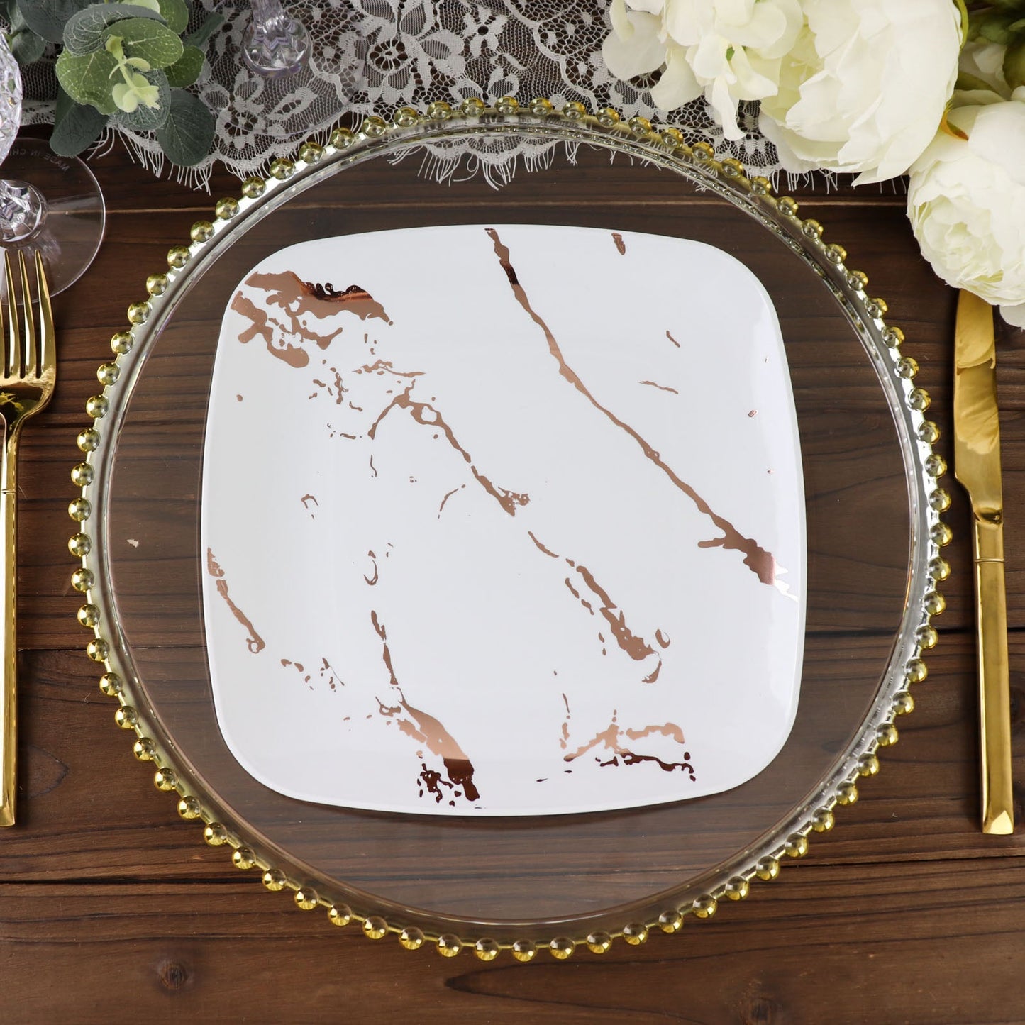 White rose gold marble square plastic dessert plate on a decorative table setting.
