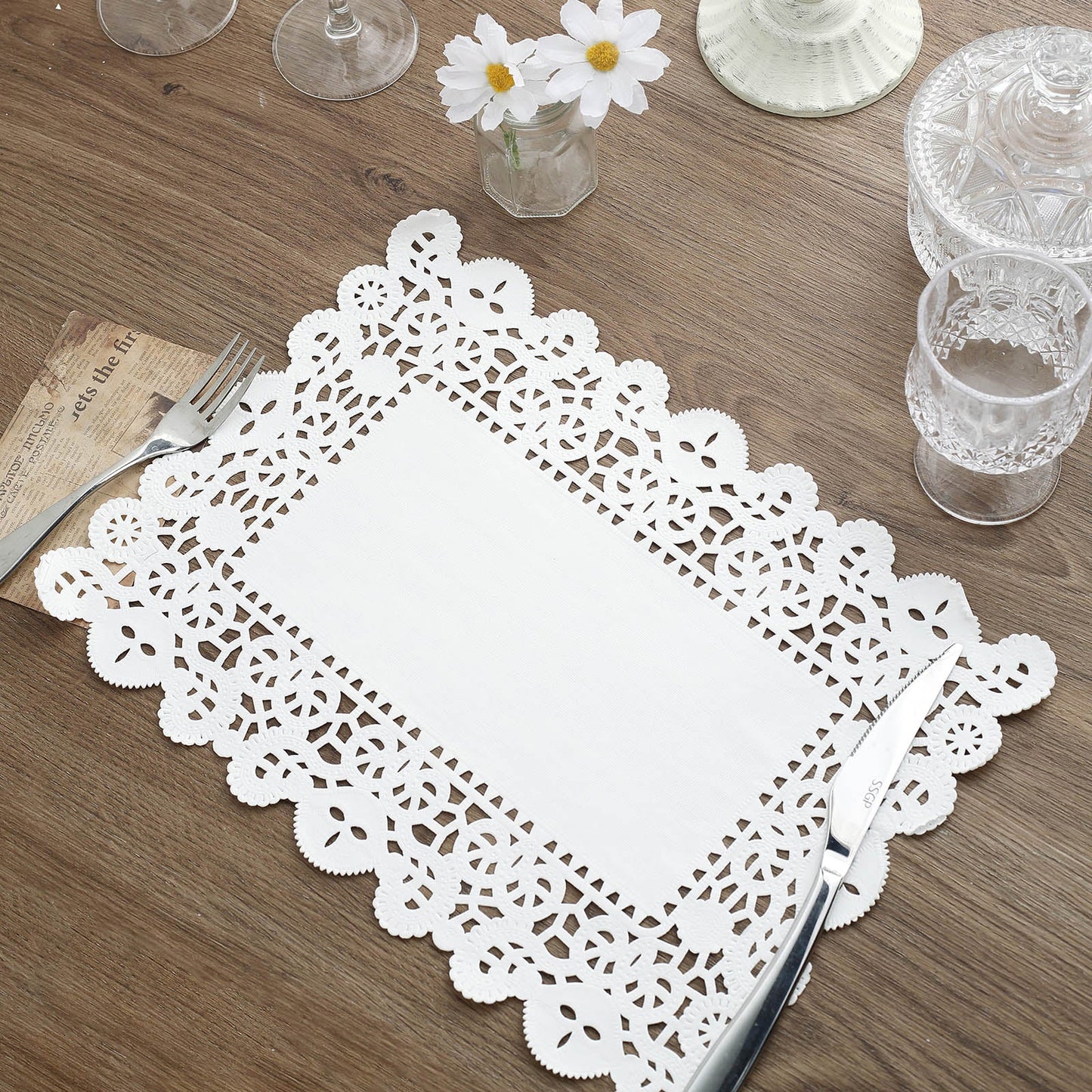 White lace paper doily placemats on a wooden table.