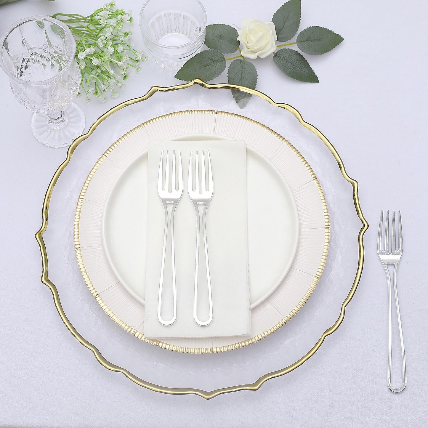 Silver disposable plastic forks on an elegant table setting.