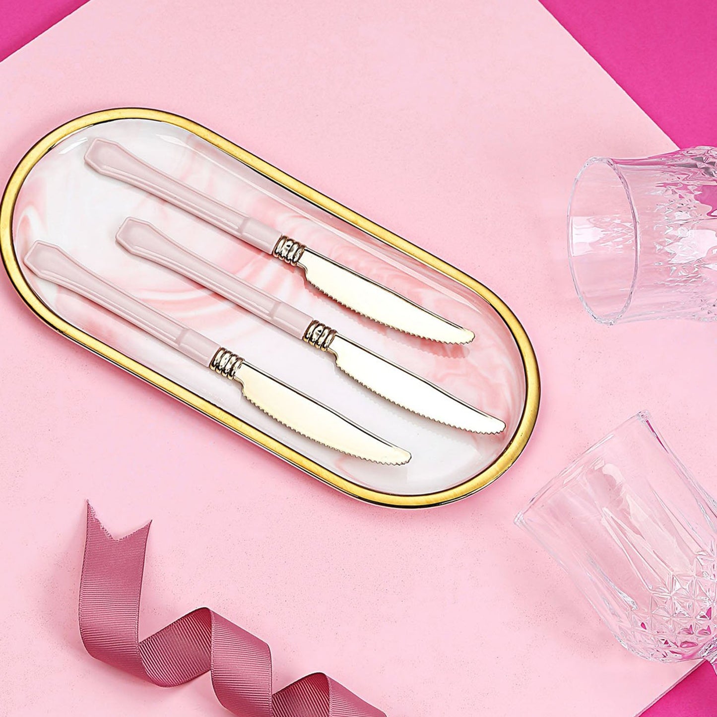 Gold 7.5" heavy-duty plastic knives with blush handles on a pink background.