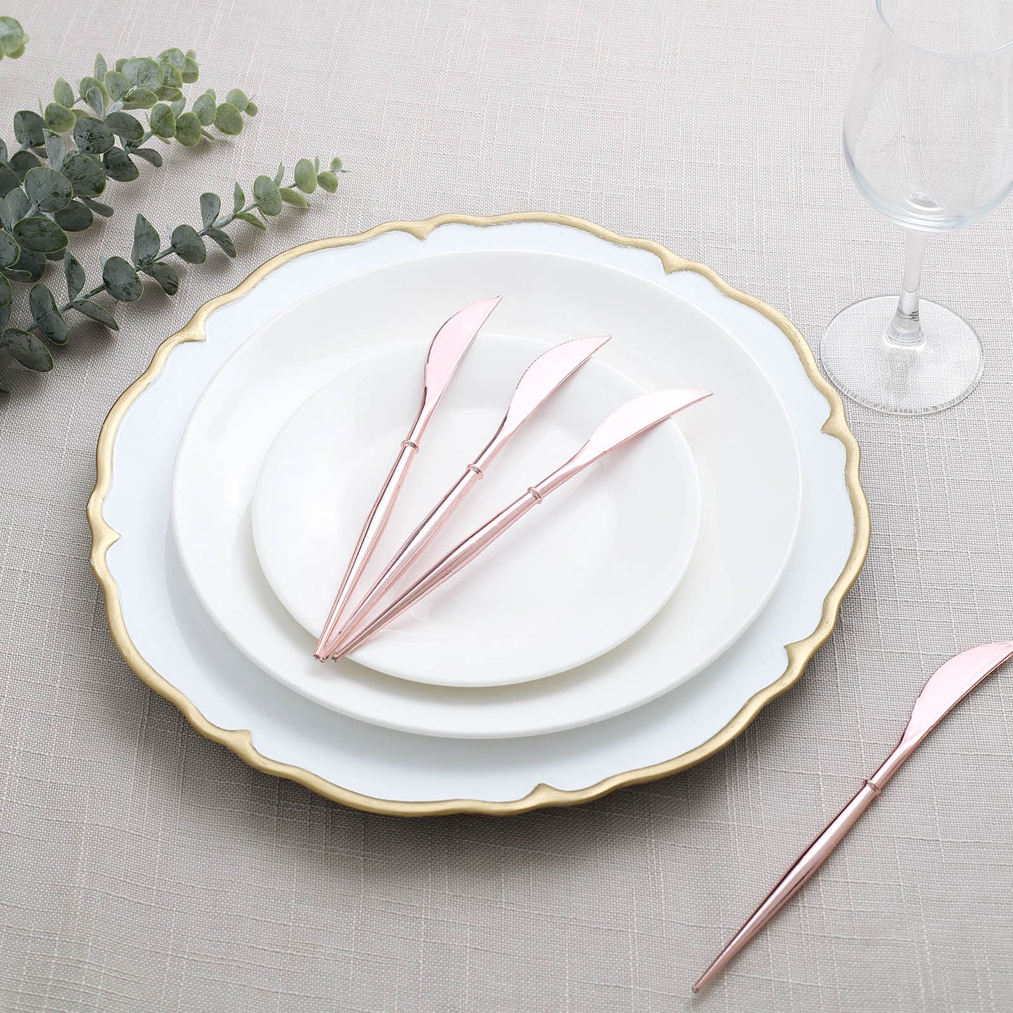 Rose gold heavy duty plastic knives on elegant table setting.