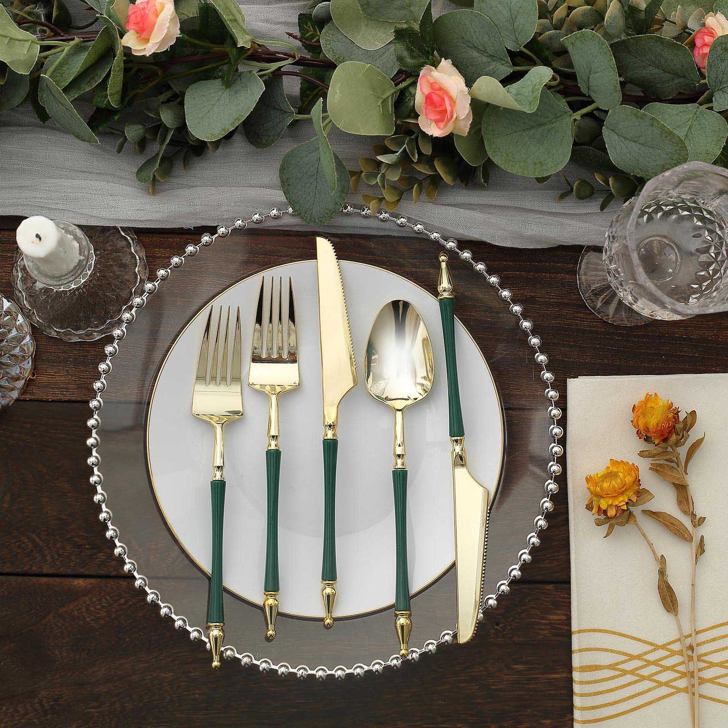 Gold and hunter emerald green disposable utensil set on a decorative plate.