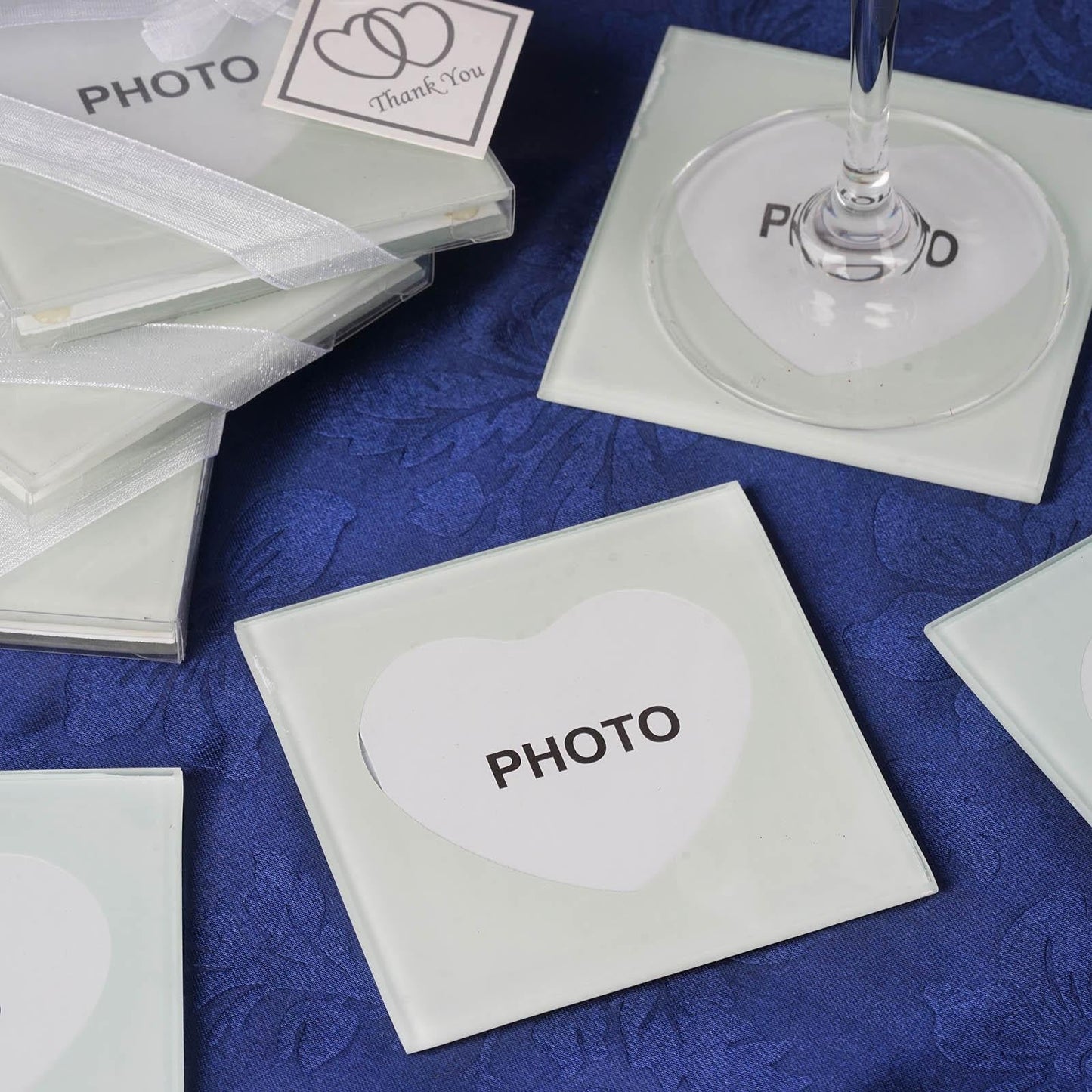 Heart-shaped glass coasters with a thank you tag on a blue surface.