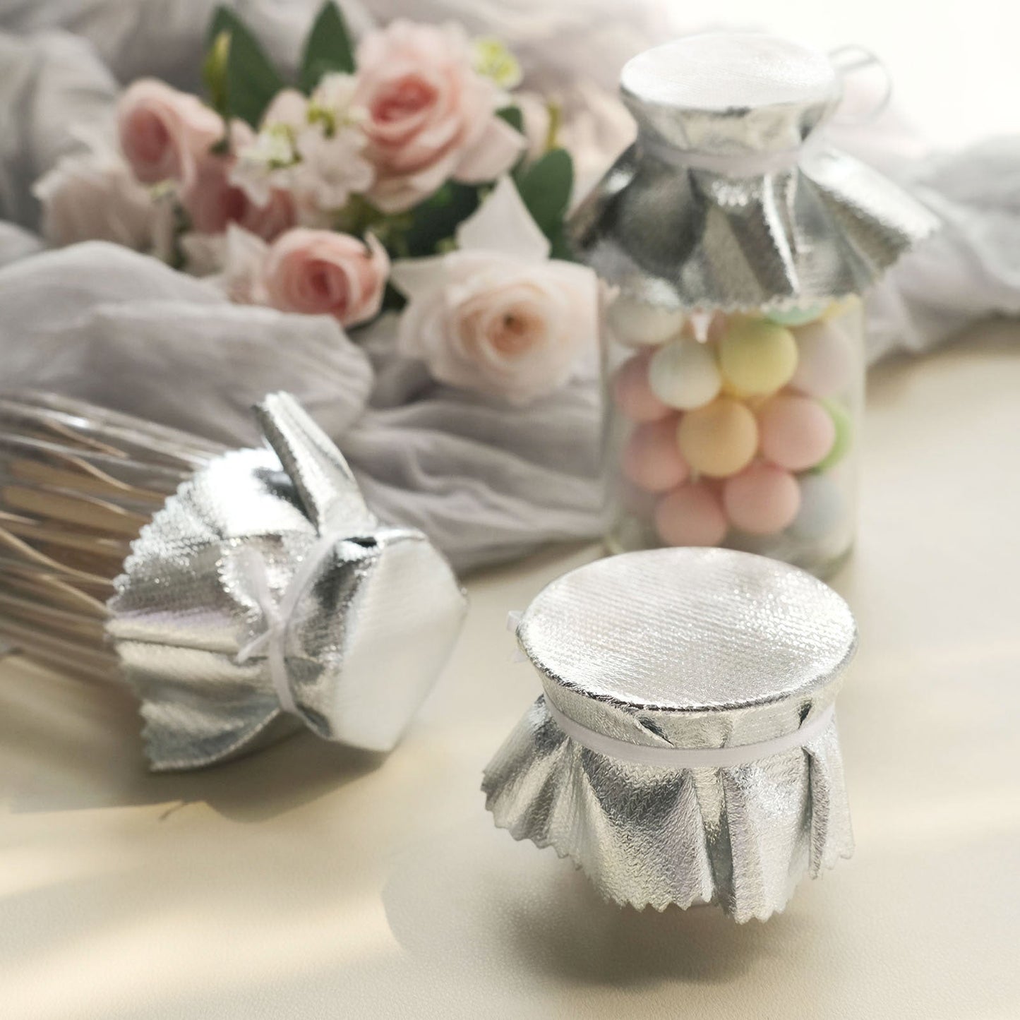 Metallic silver party favor jar covers with satin tie string.