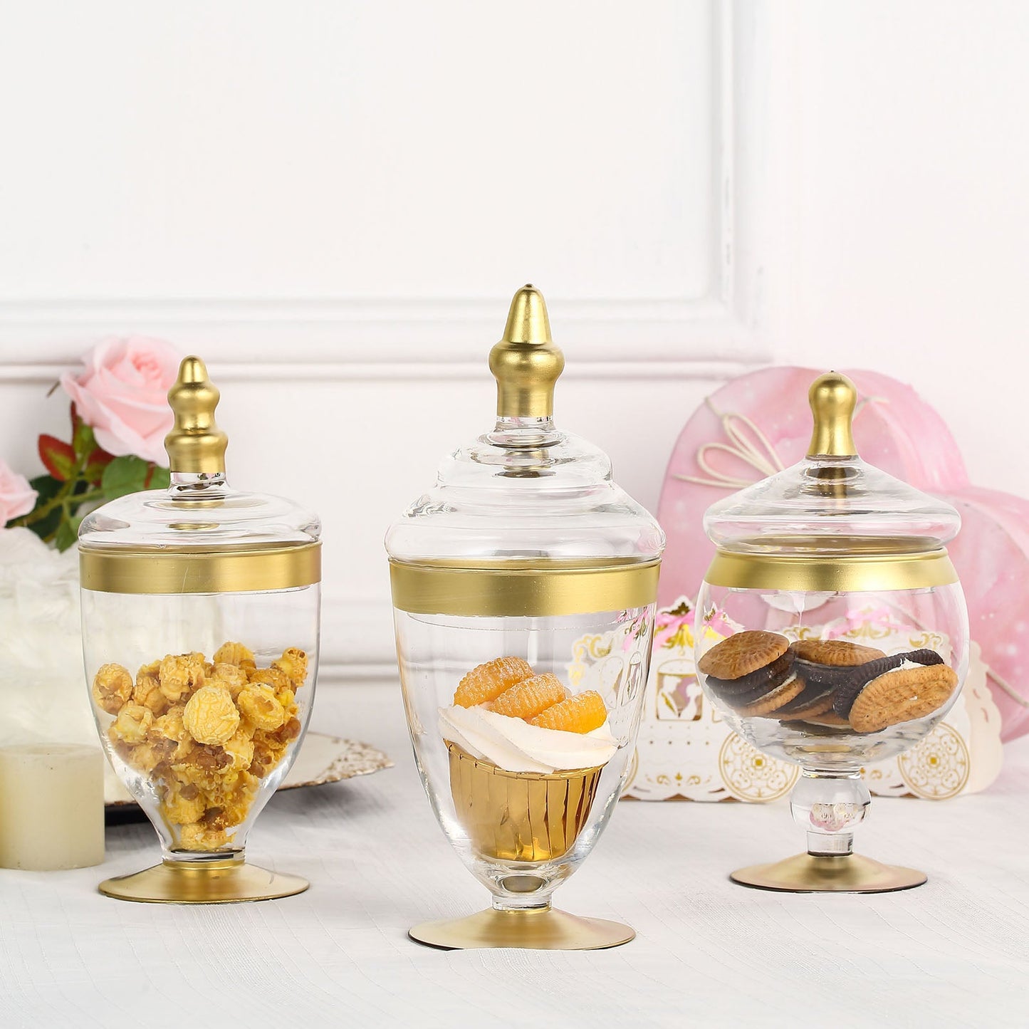 Gold trim clear apothecary jars with snap-on lids for decorative storage.