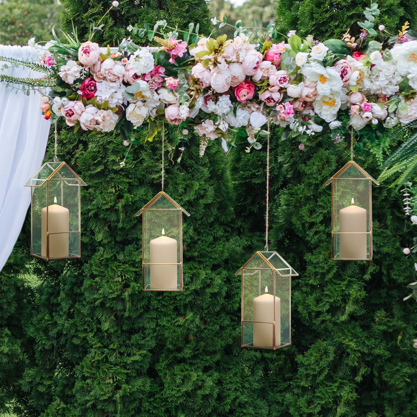 Gold geometric glass lanterns hanging among flowers and greenery.