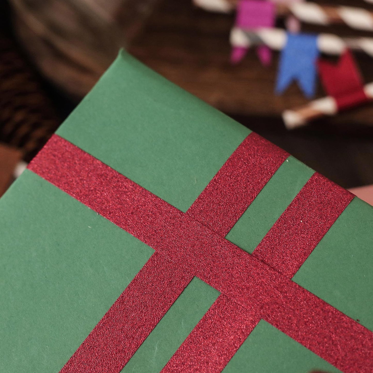 Burgundy glitter washi tape on green wrapping paper.