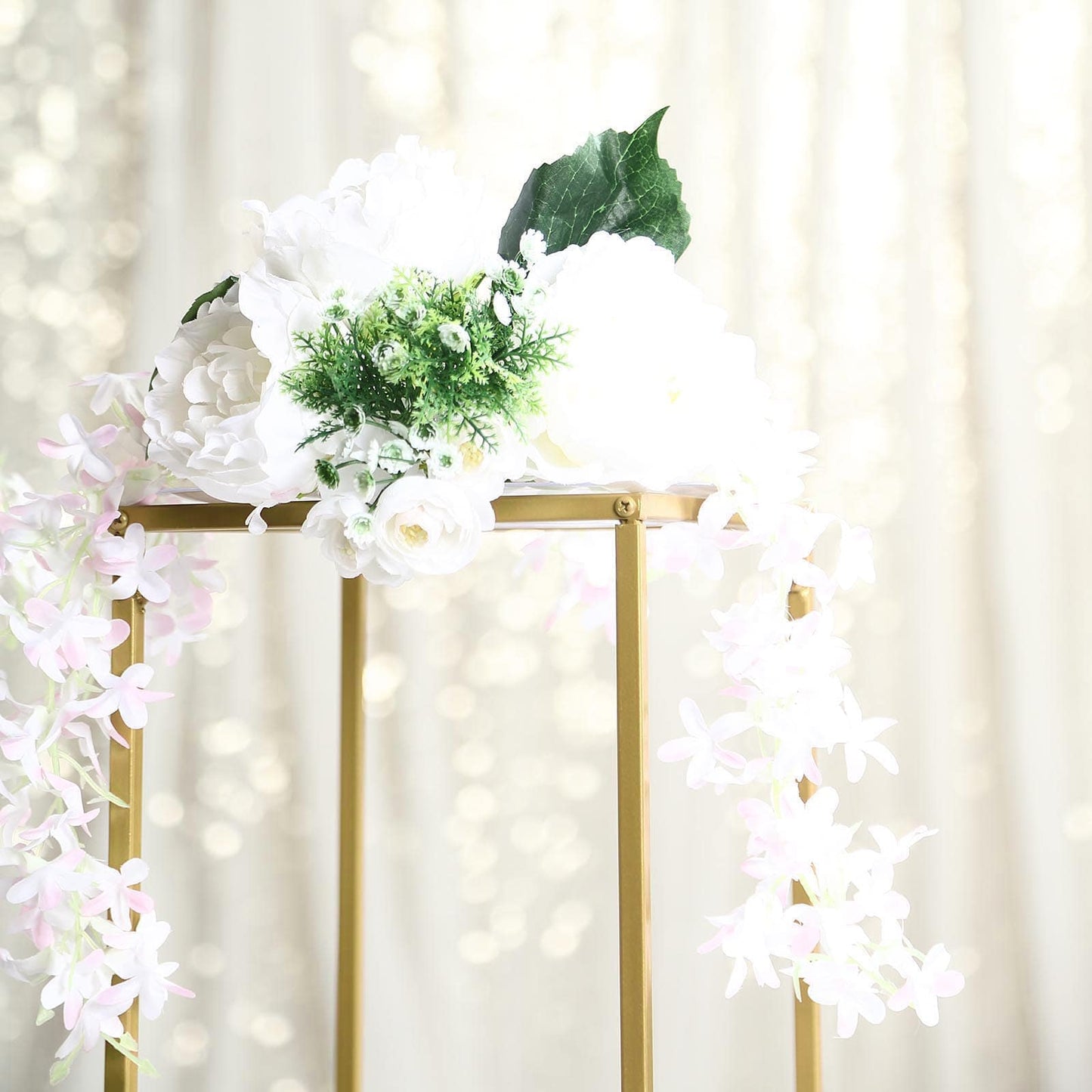 Gold metal wedding flower stand with white and pink floral arrangement.
