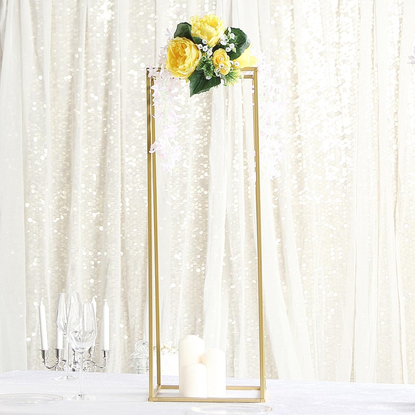 Gold metal rectangular wedding flower stand with floral arrangement.