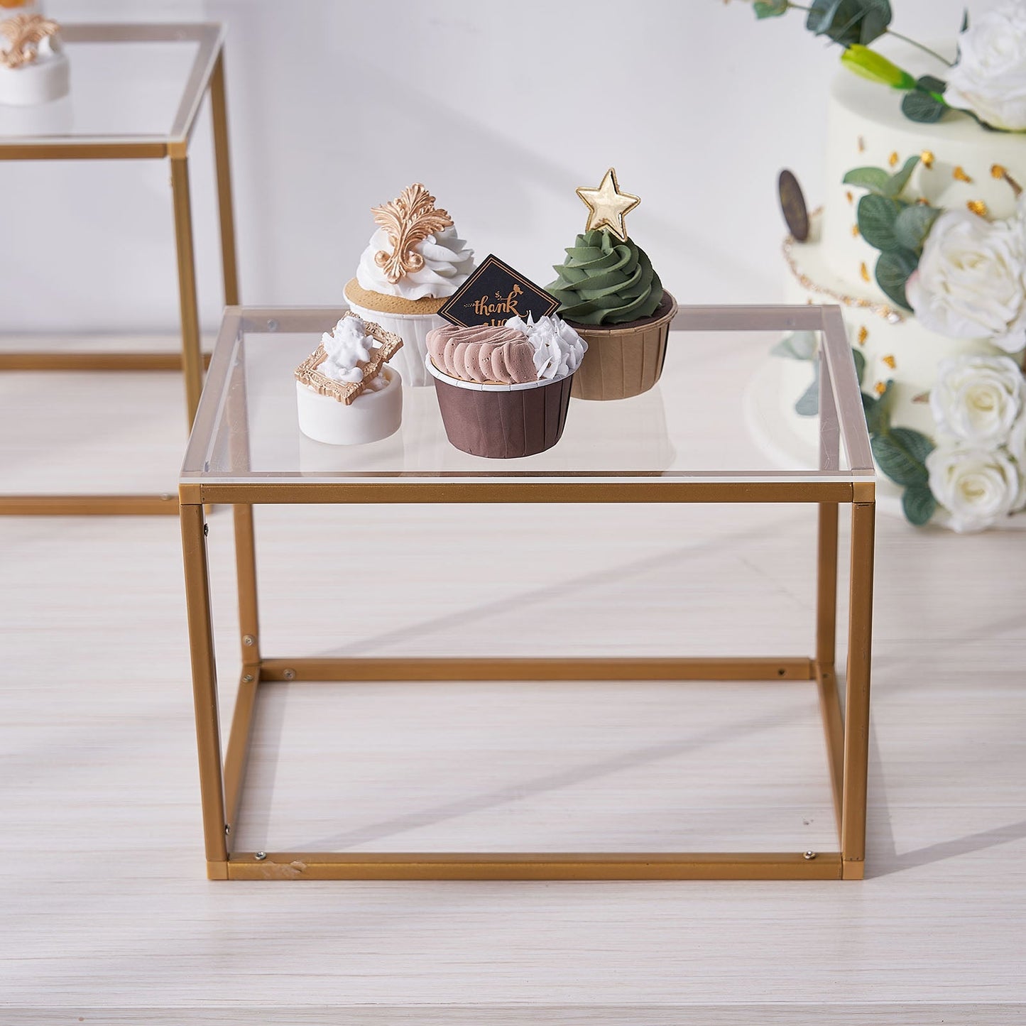Clear acrylic sheets on a display table with decorative cupcakes.