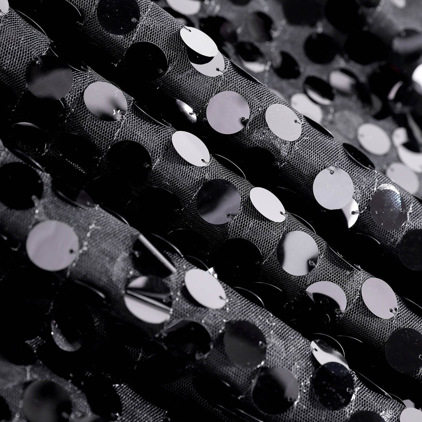 Black sequin table overlay with shimmering circular accents.