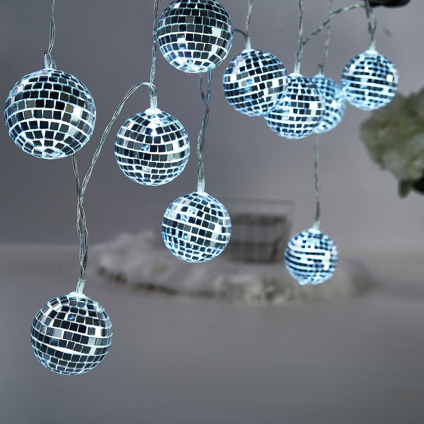 Silver disco mirror ball LED string lights with a cool white glow.