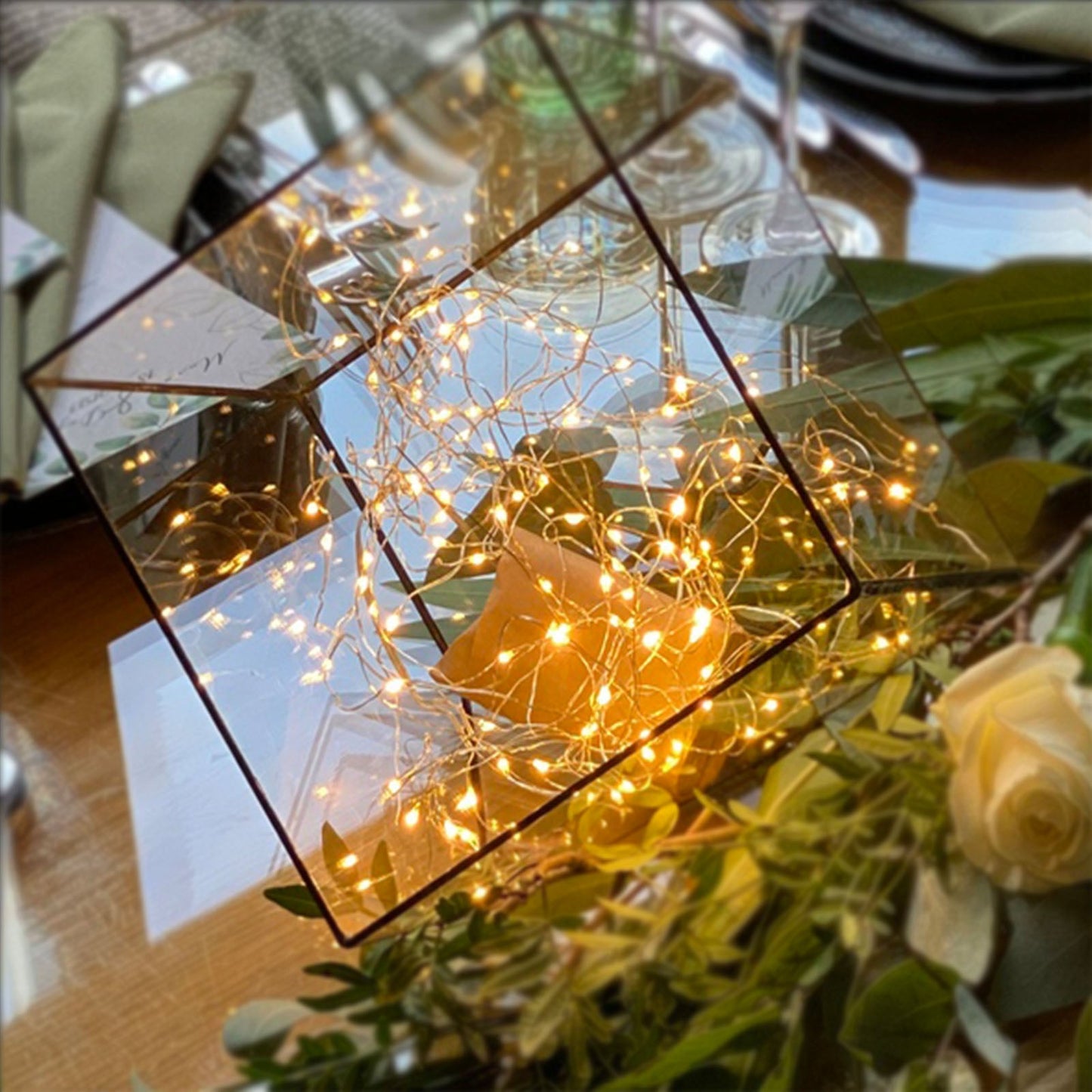 Warm white 200 LED battery-operated fairy string lights on a table arrangement.