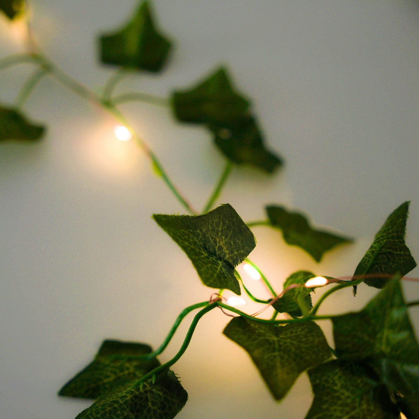 Green silk ivy garland vine string lights with warm white LED glow.
