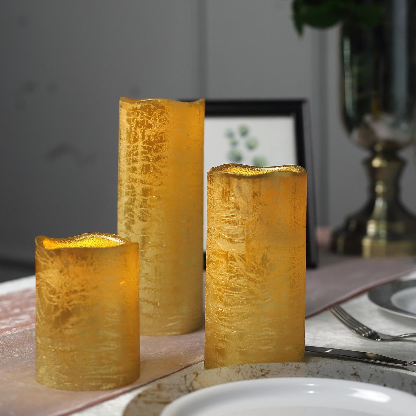 Metallic gold LED pillar candles set of 3, flameless and remote-operated.