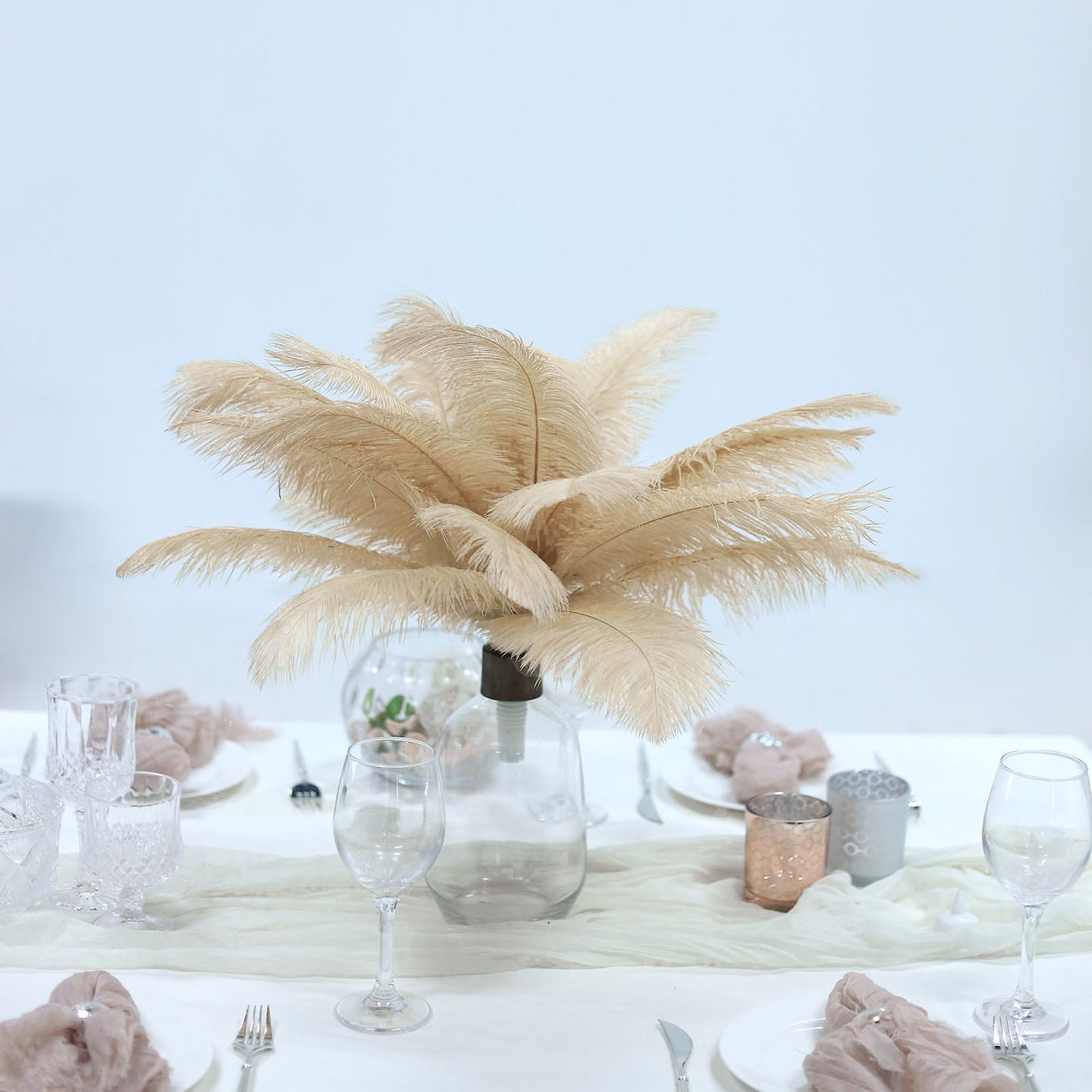 Beige natural plume ostrich feathers in a vase centerpiece arrangement.