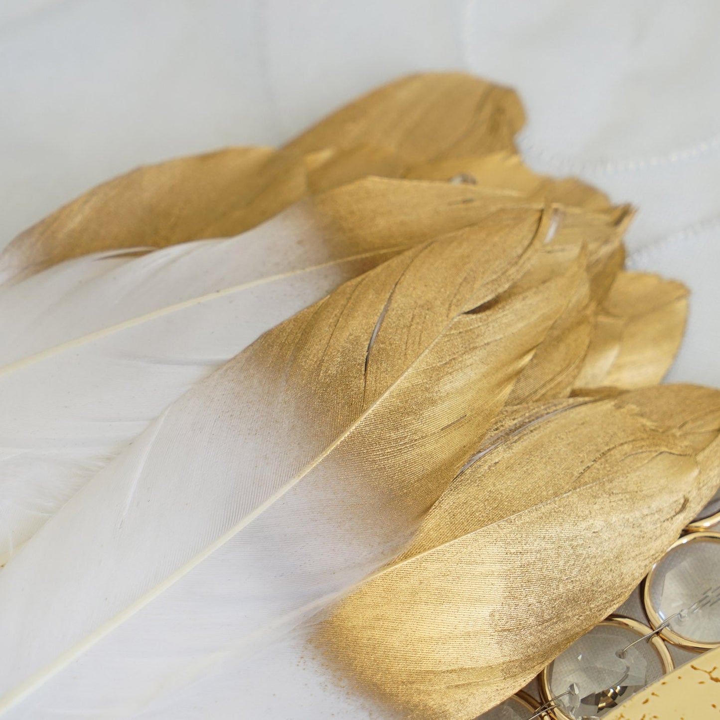 Metallic gold dipped white goose feathers for party decoration.