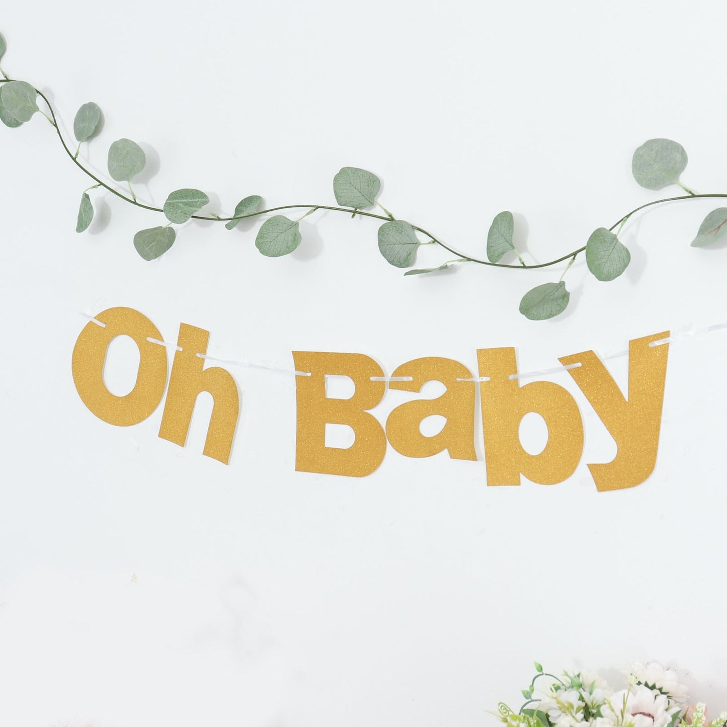 Gold glittered "Oh Baby" garland banner for baby shower decoration.