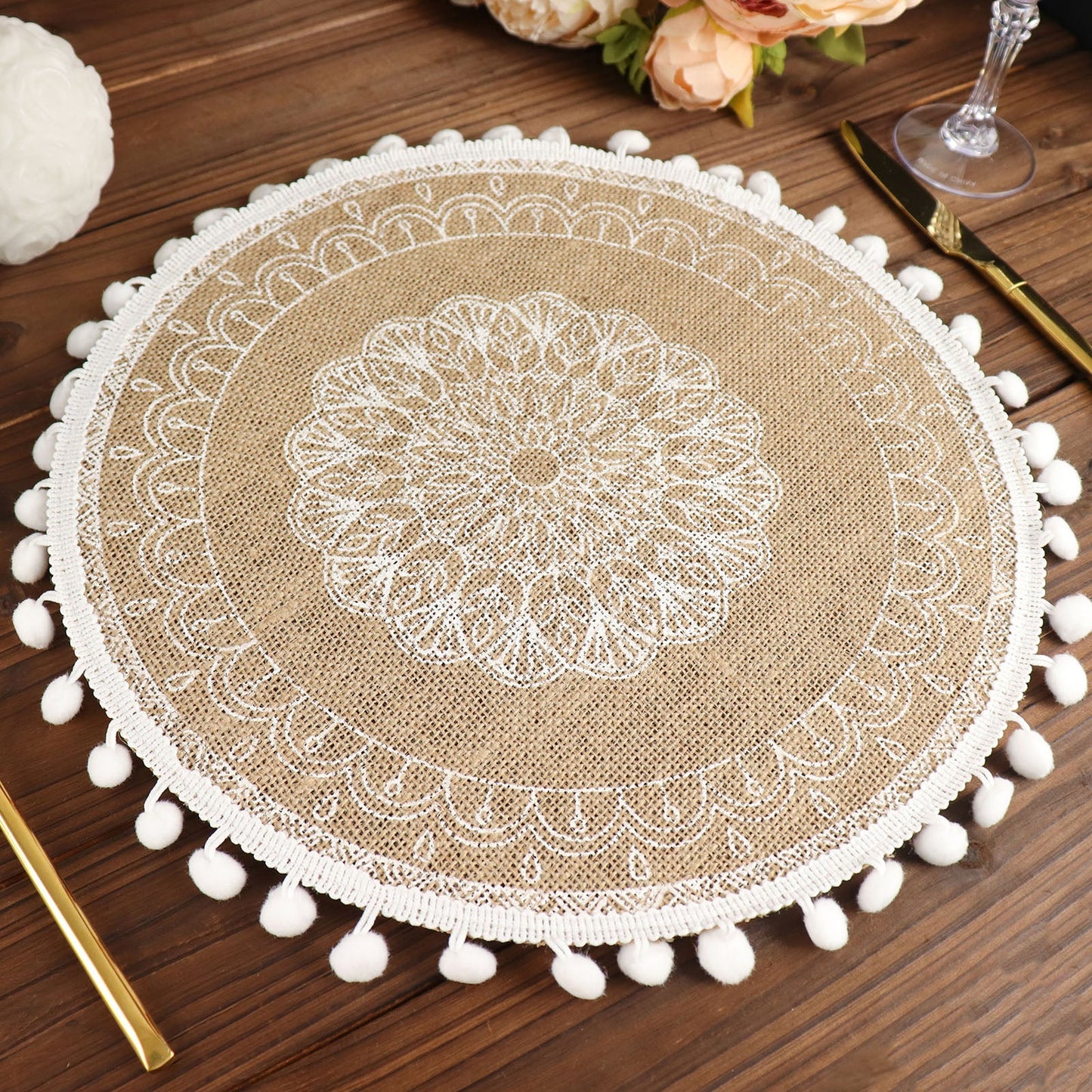 Natural jute round placemat with white embroidery and tassels.