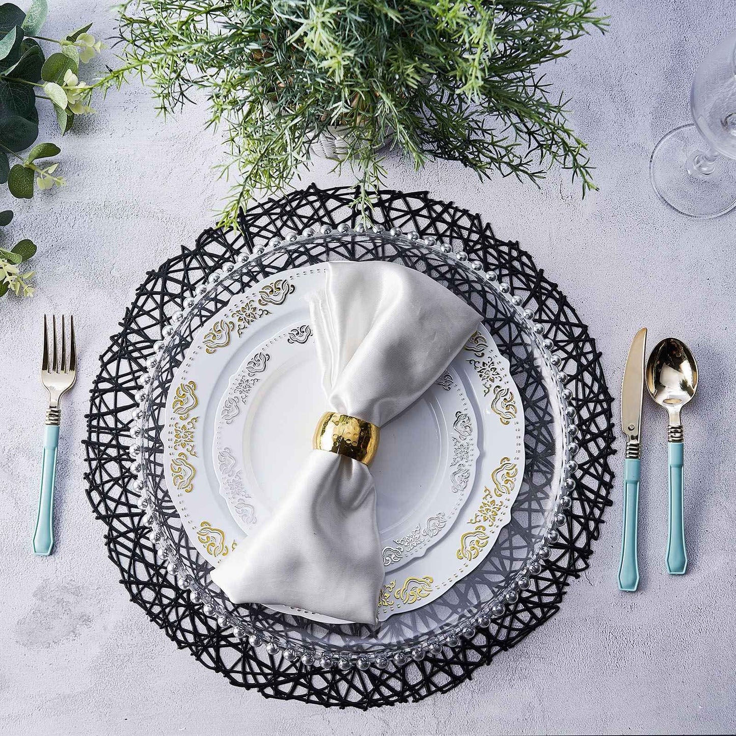 Black vinyl placemats on a table setting with white plates and silver utensils.