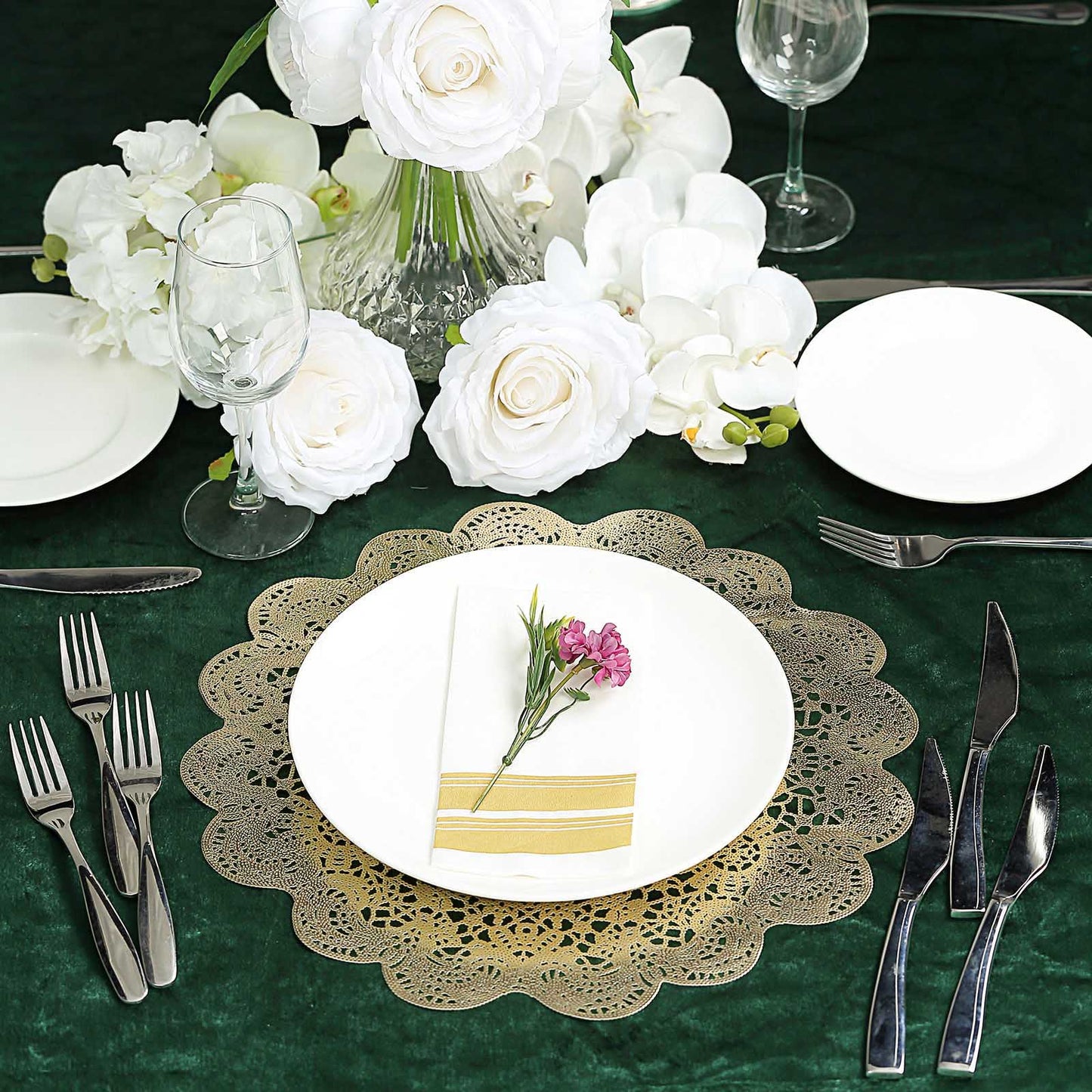 Gold vintage floral lace placemats on a dining table with white flowers.