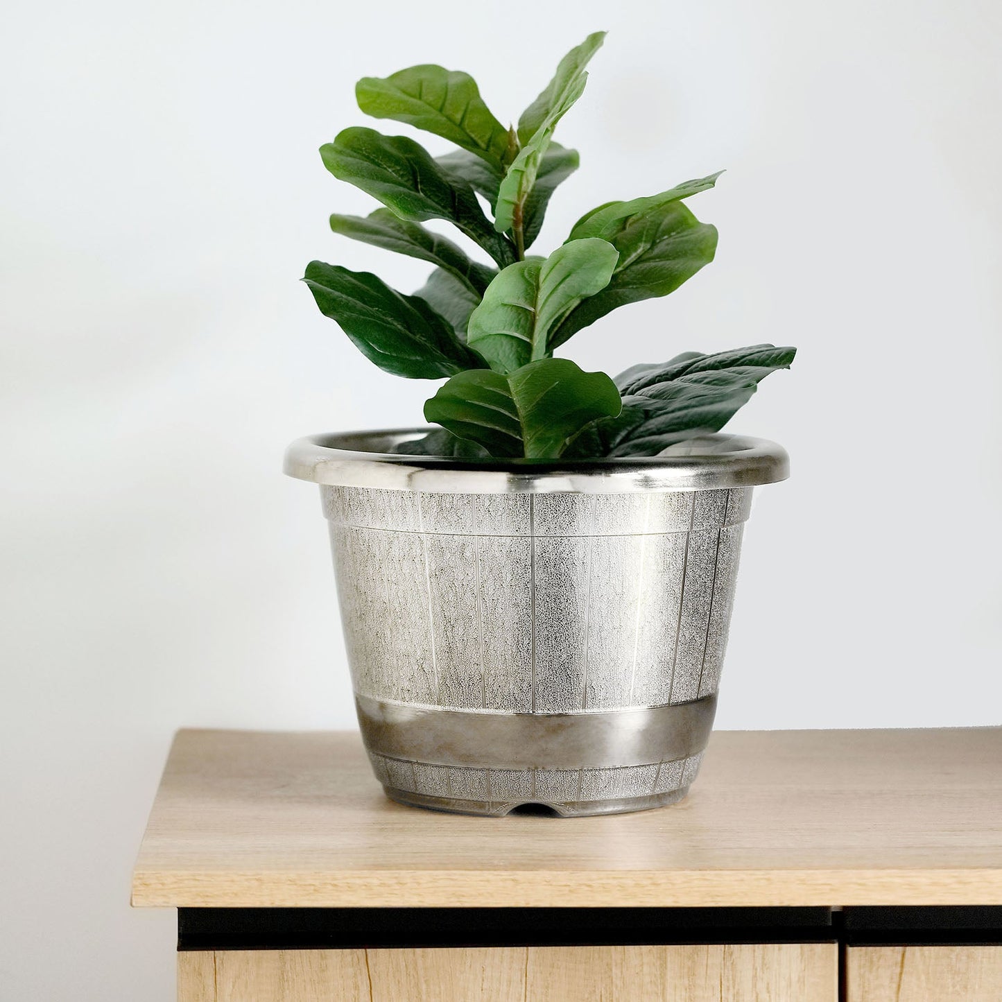 Silver chrome finished large barrel planter pot with greenery.