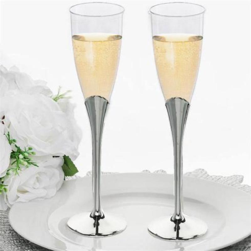 Clear silver plastic champagne flutes on a plate with sparkling drink.