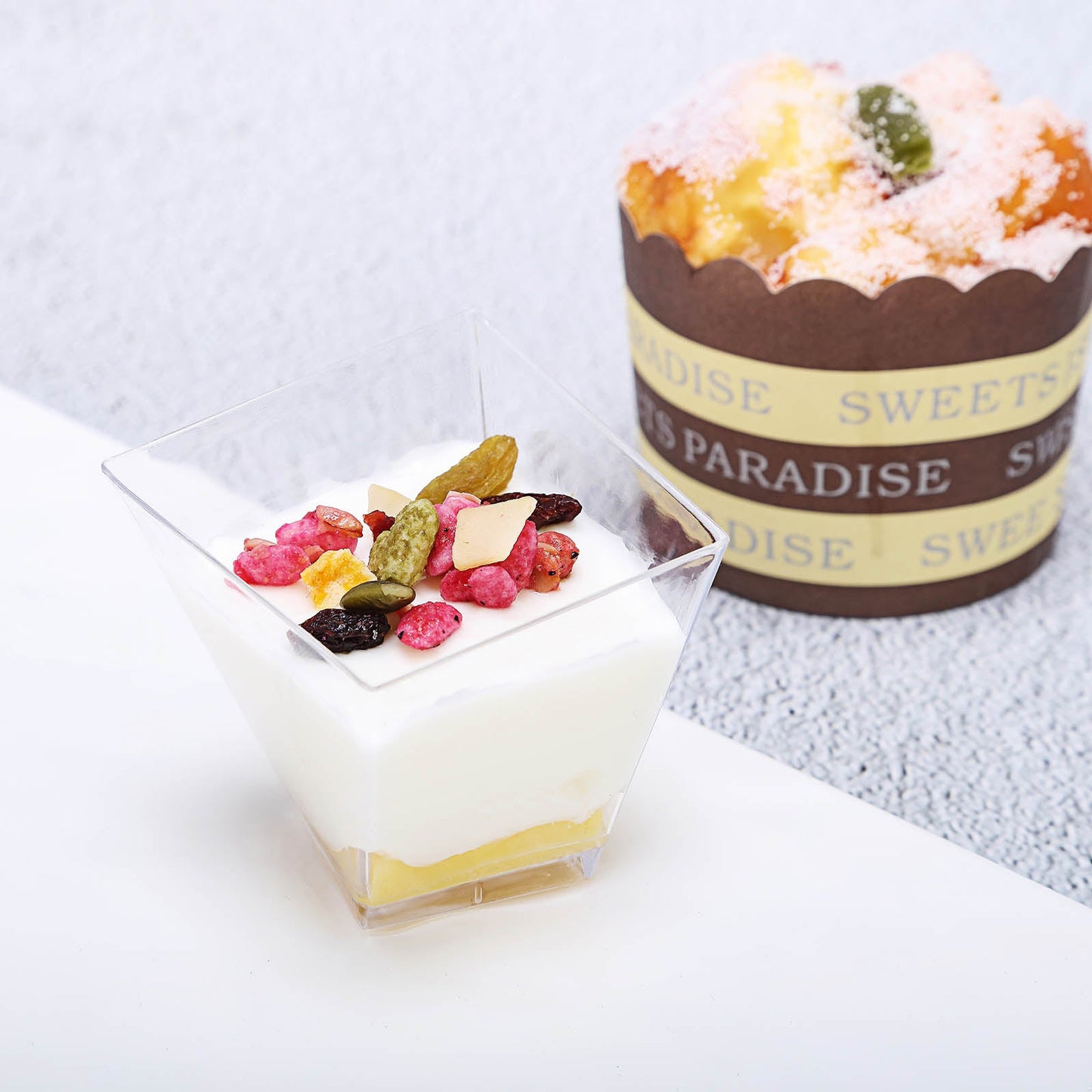 Clear square twist plastic dessert cup with dessert and toppings.