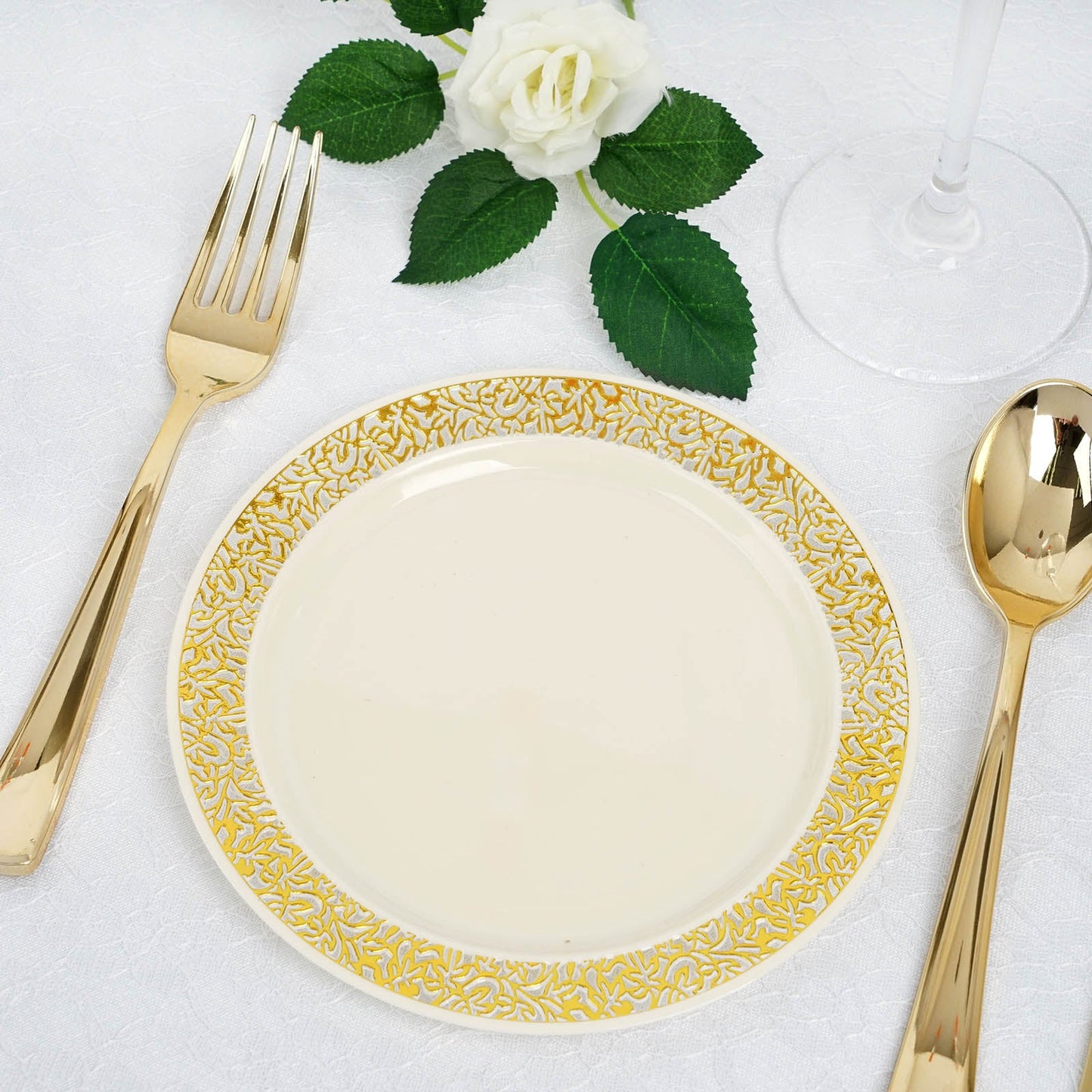 Gold lace rim ivory plastic dessert plate with gold utensils.