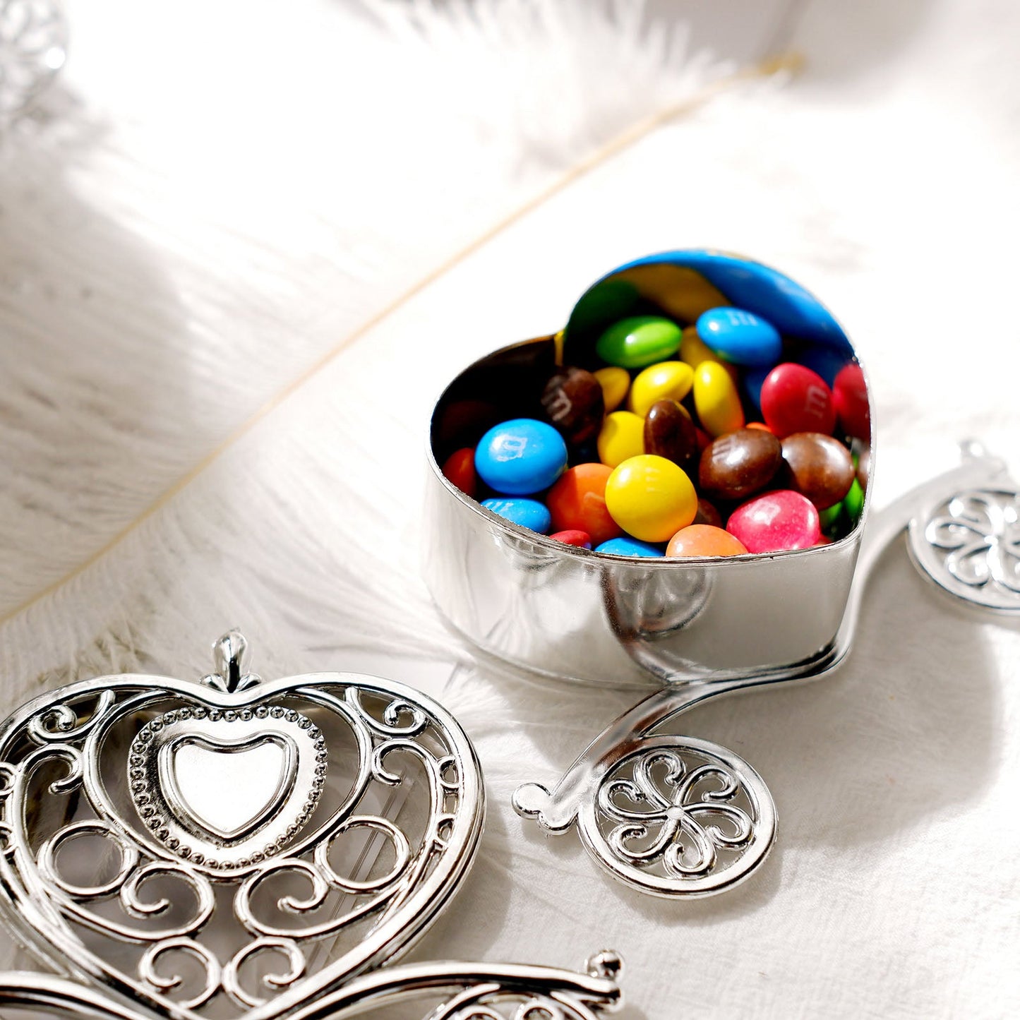 Silver heart carriage party favor gift box with colorful candies inside.