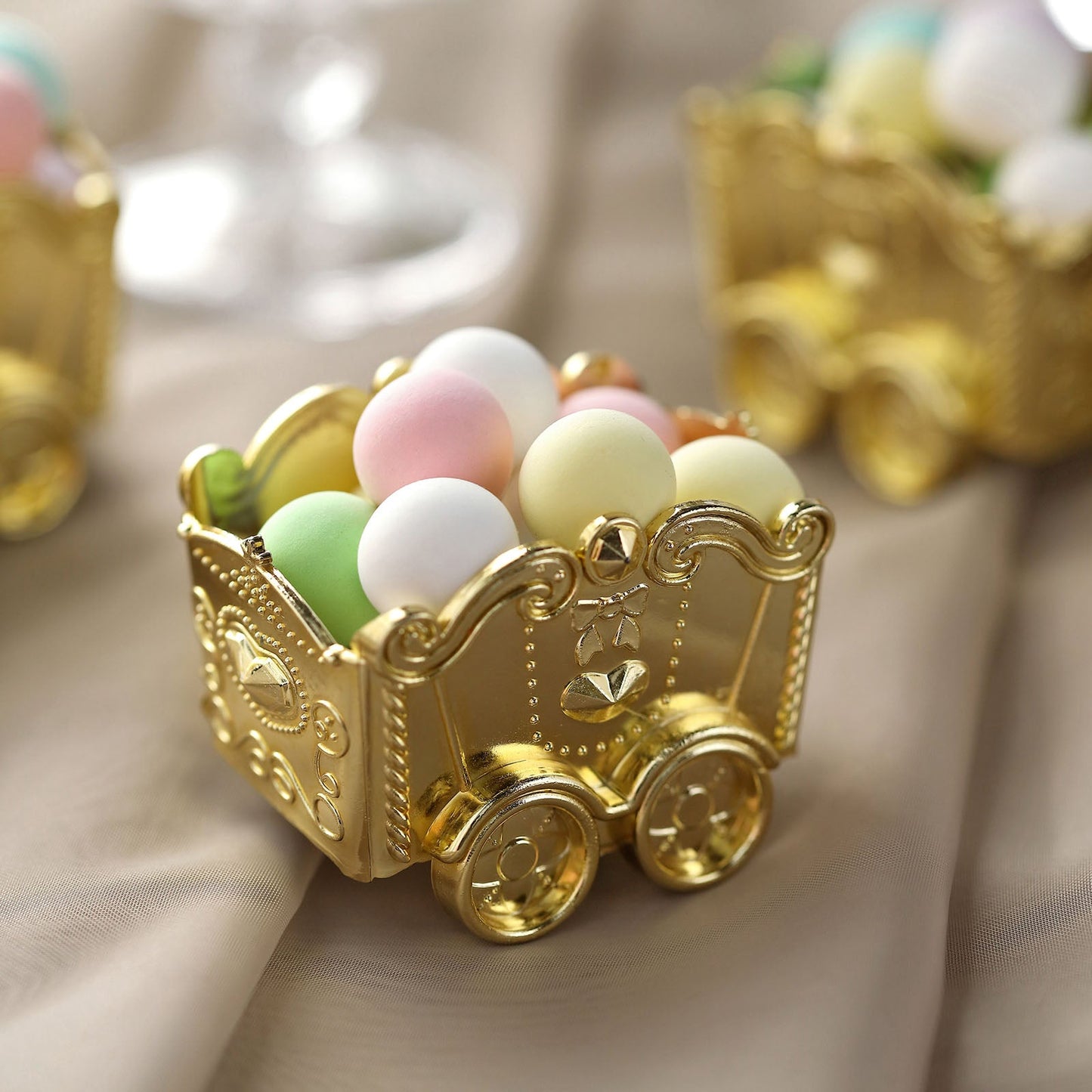 Gold party favor gift boxes filled with colorful candy treats.