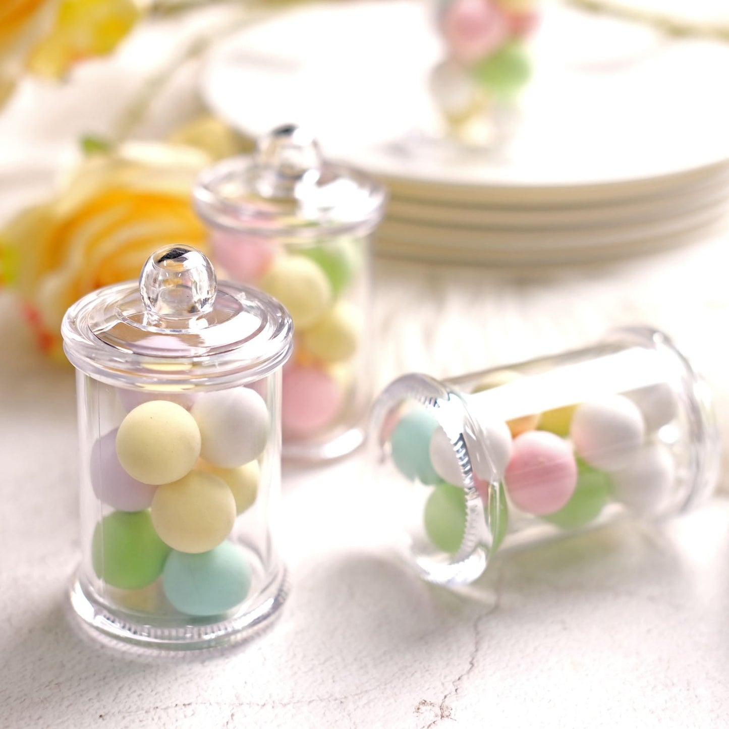 Clear plastic candy jars filled with pastel-colored candies.