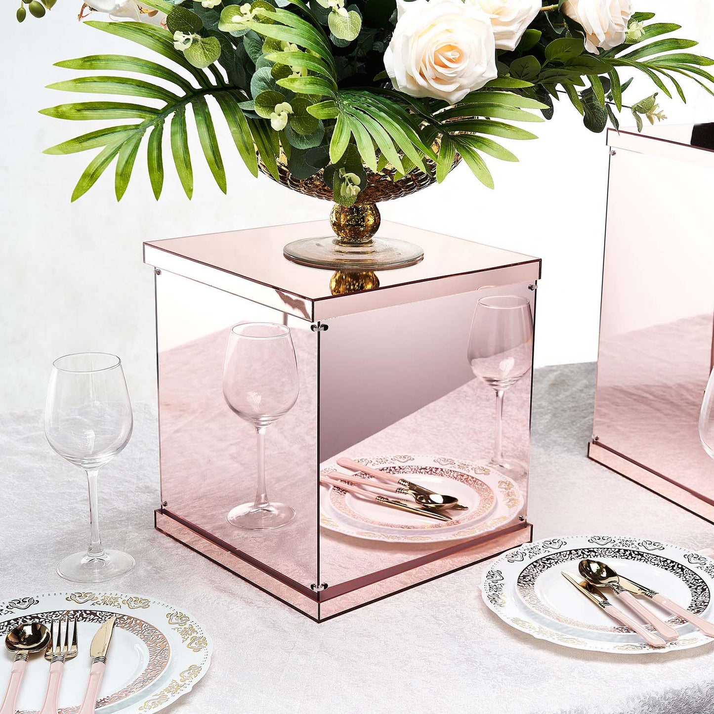 Rose gold mirrored acrylic pedestal risers for elegant table displays.