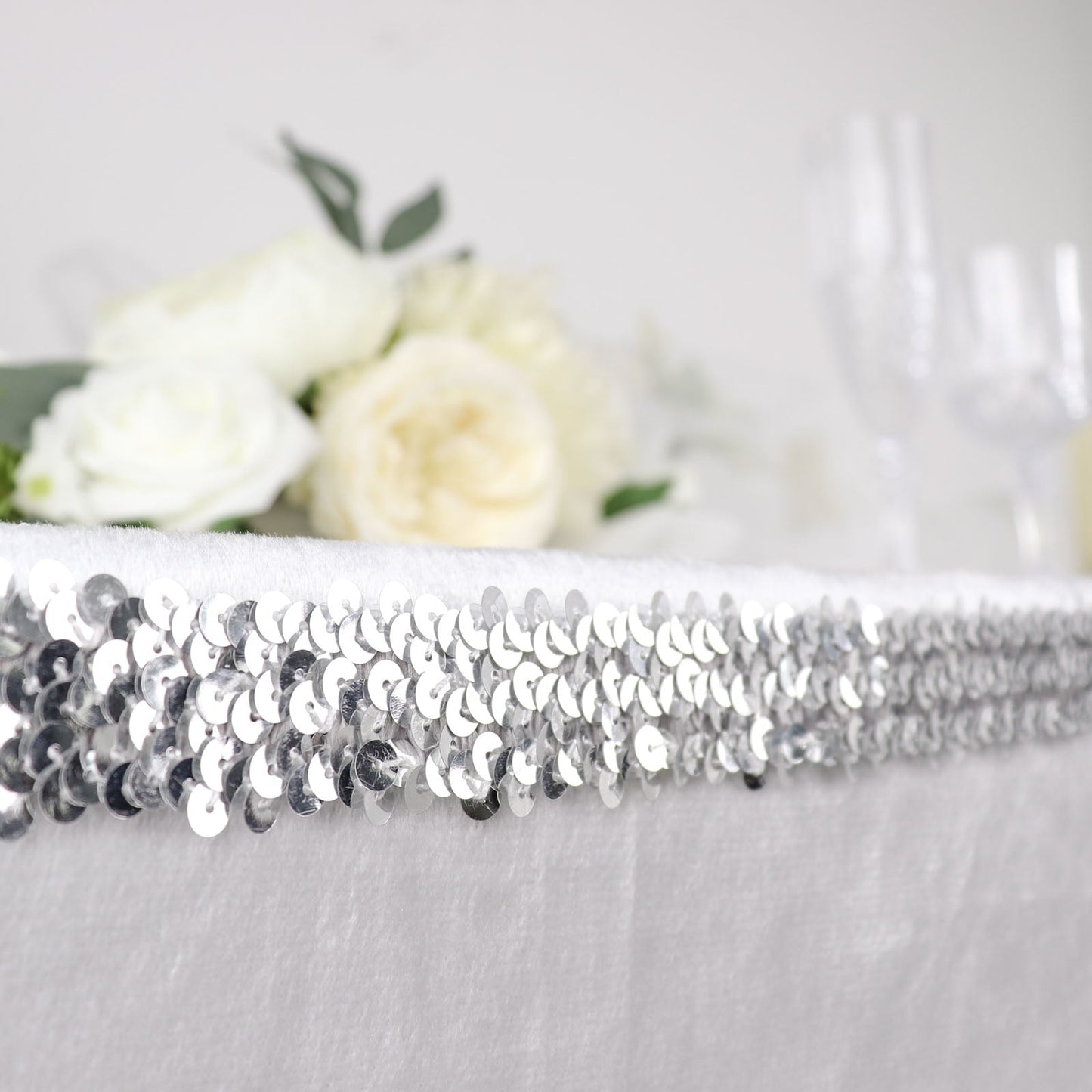 Metallic silver sequin stretch fabric ribbon with shiny glitter accents.