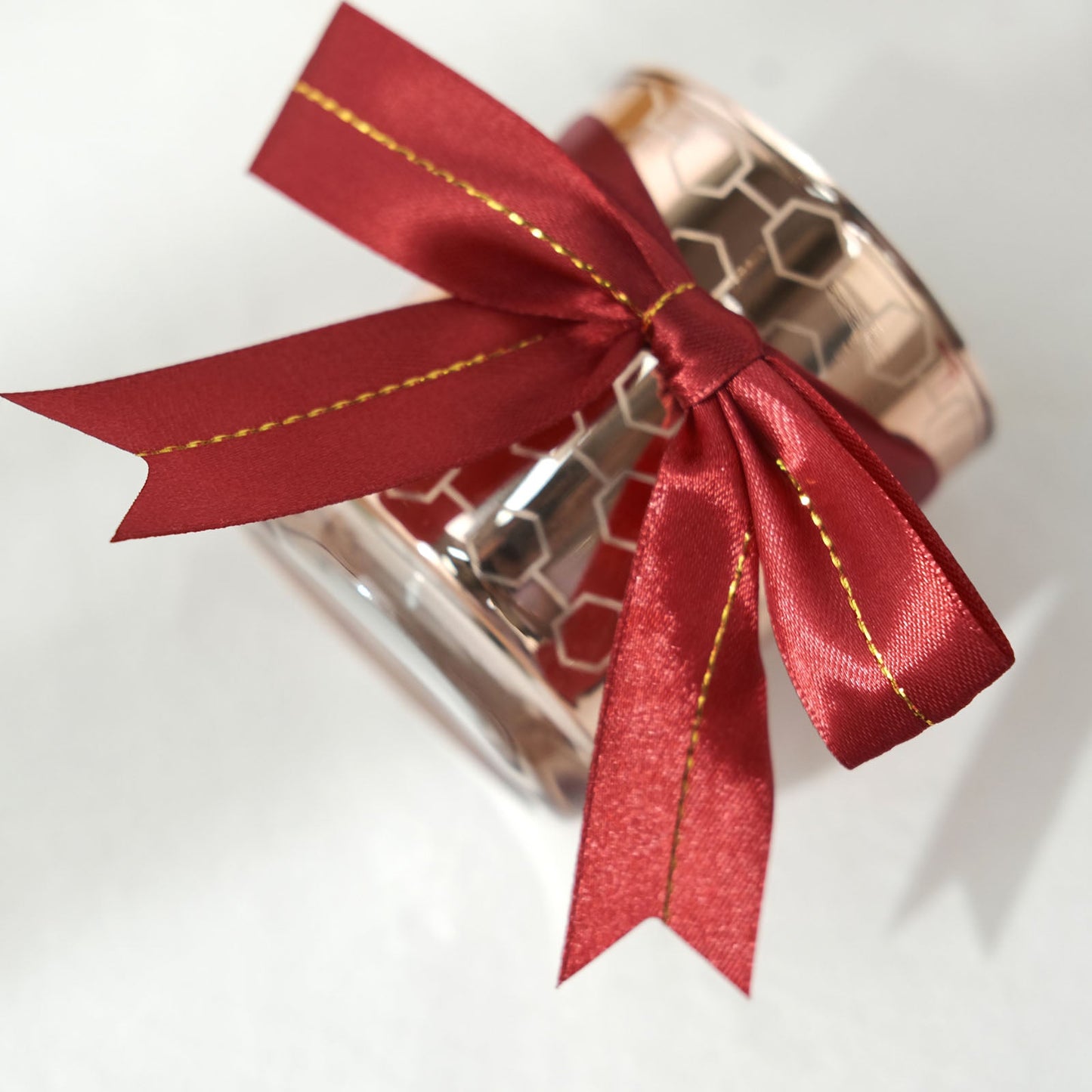 Burgundy satin ribbon bow with gold foil lining on a gift basket.