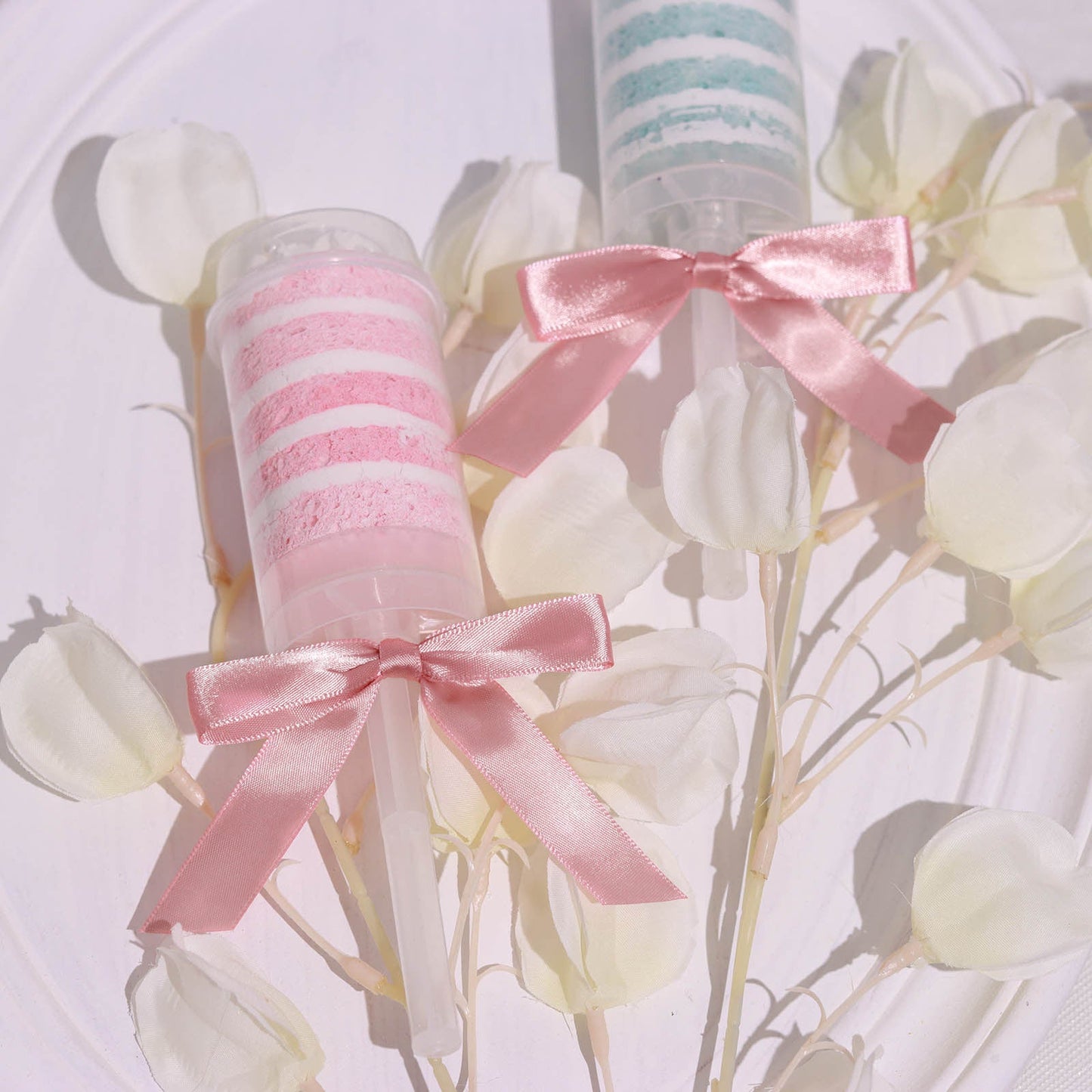 Dusty rose satin ribbon bows on decorative party favors.
