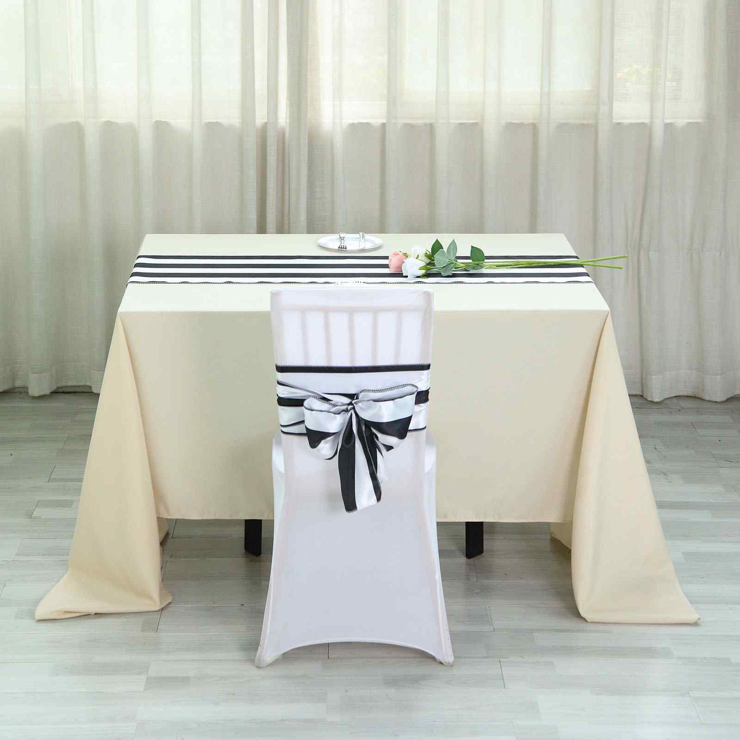 Black and white stripe satin table runner on a table setting.