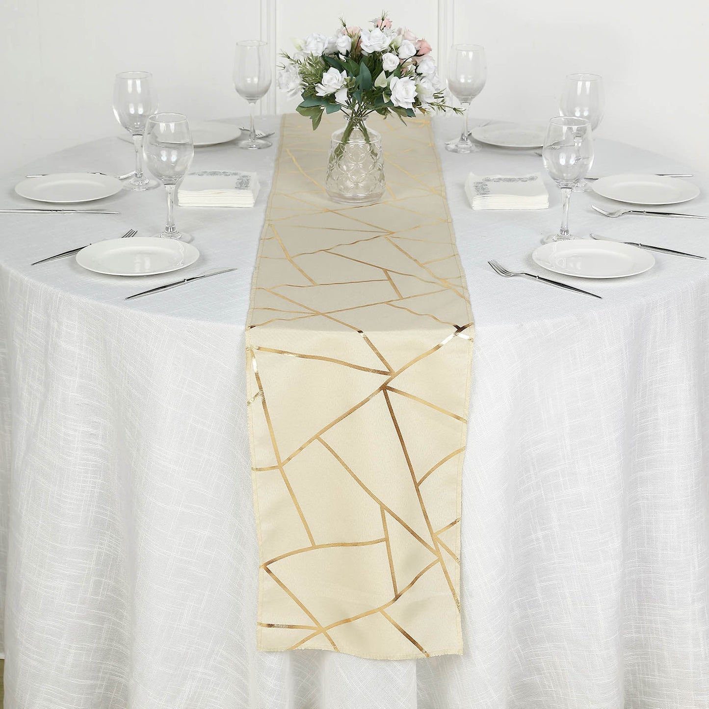 Beige geometric pattern table runner with gold foil accents on a white table.
