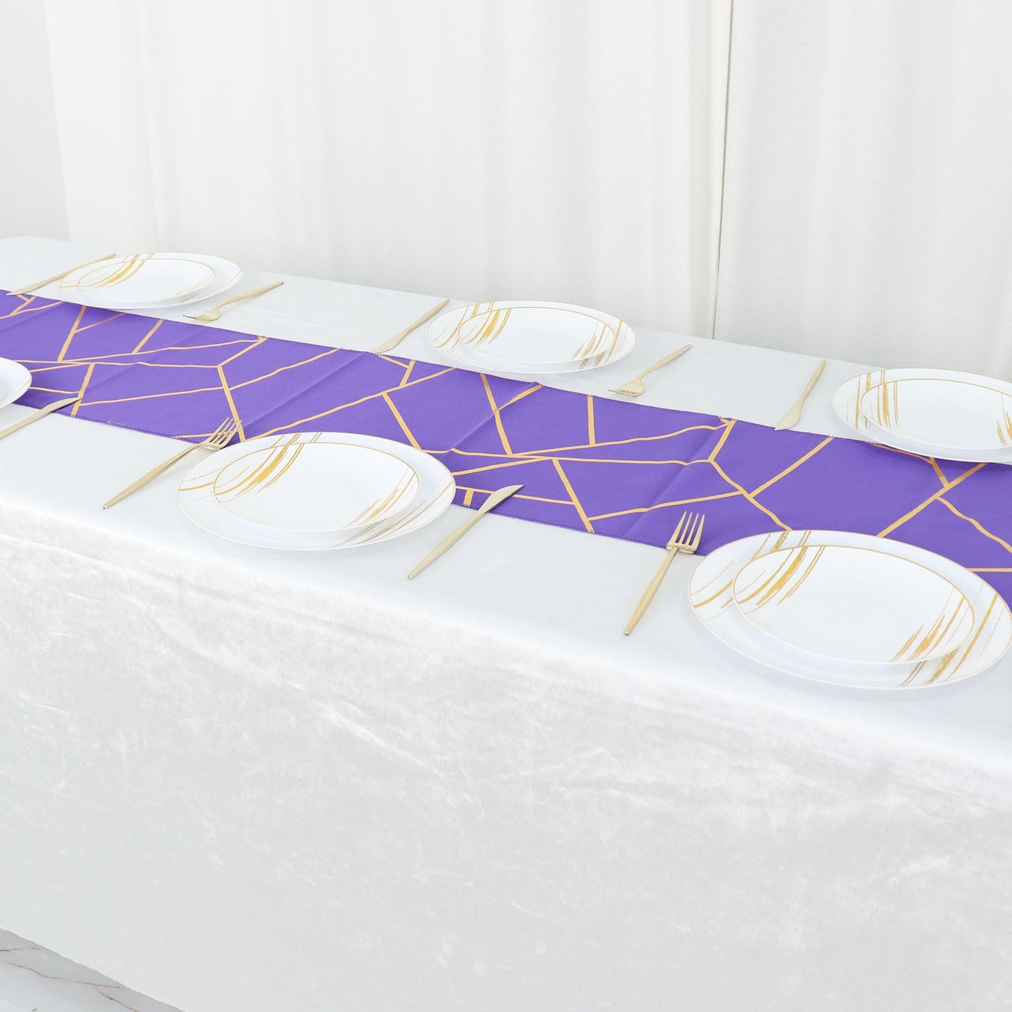Purple geometric table runner with gold foil pattern on a dining table.